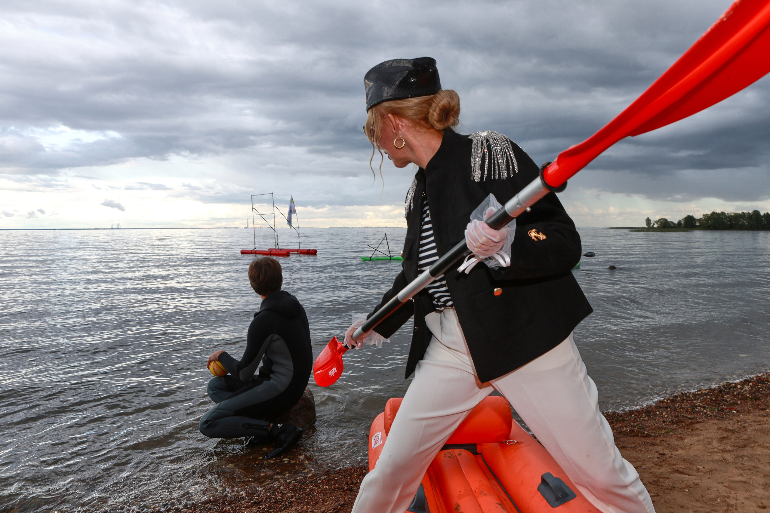 Парная фотография девушки в элегантном морском стиле: стильный костюм, изящно держащая весло на живописном берегу залива. 