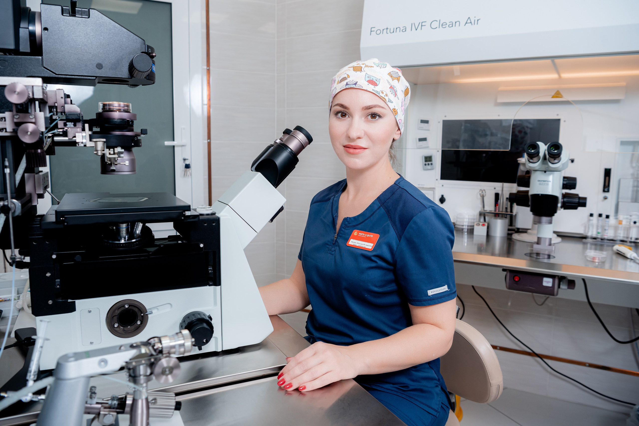 Стерильная атмосфера лаборатории ЭКО: техник за микроскопом, профессиональная фотосъемка.