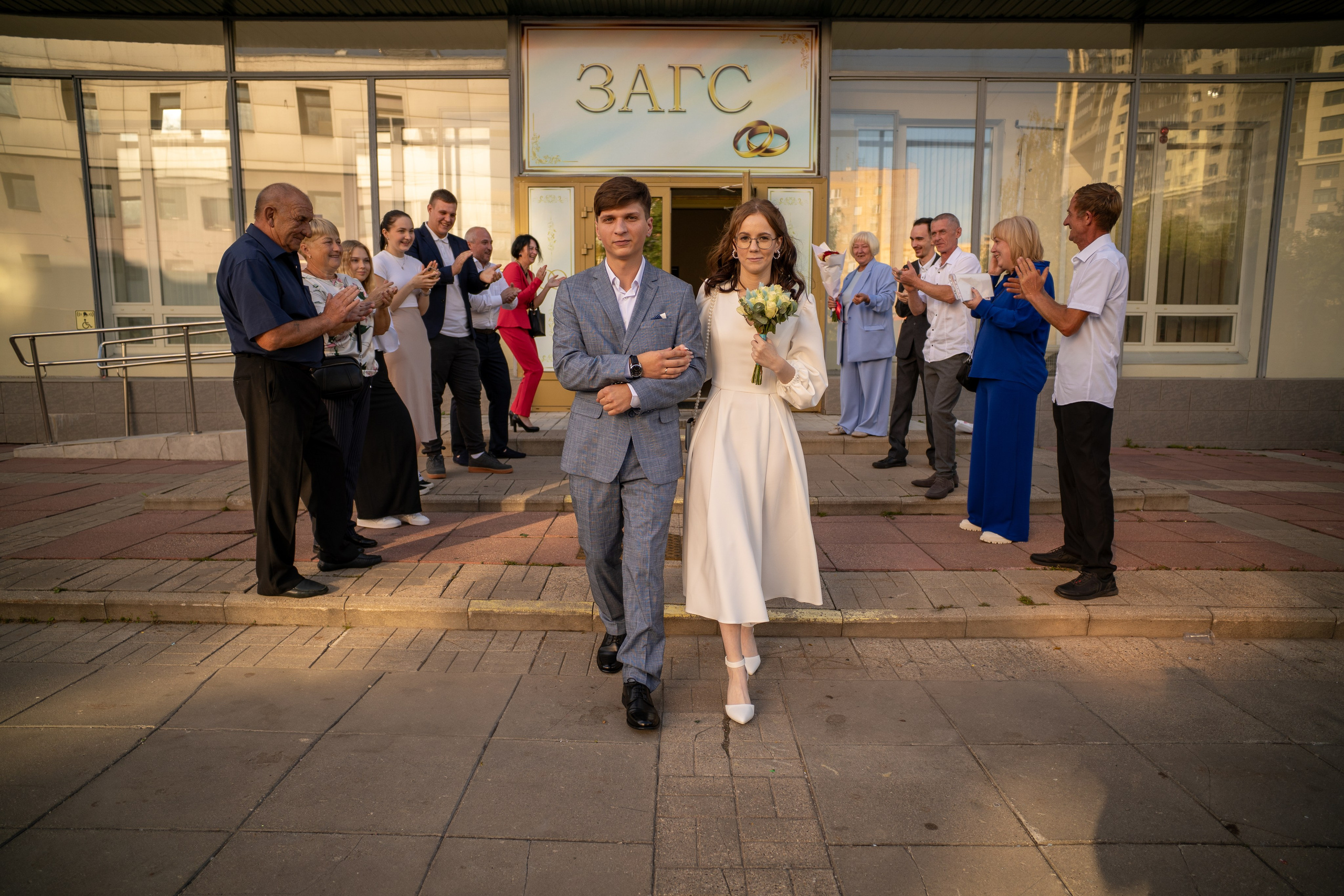 Молодожены выходят после росписи из загса