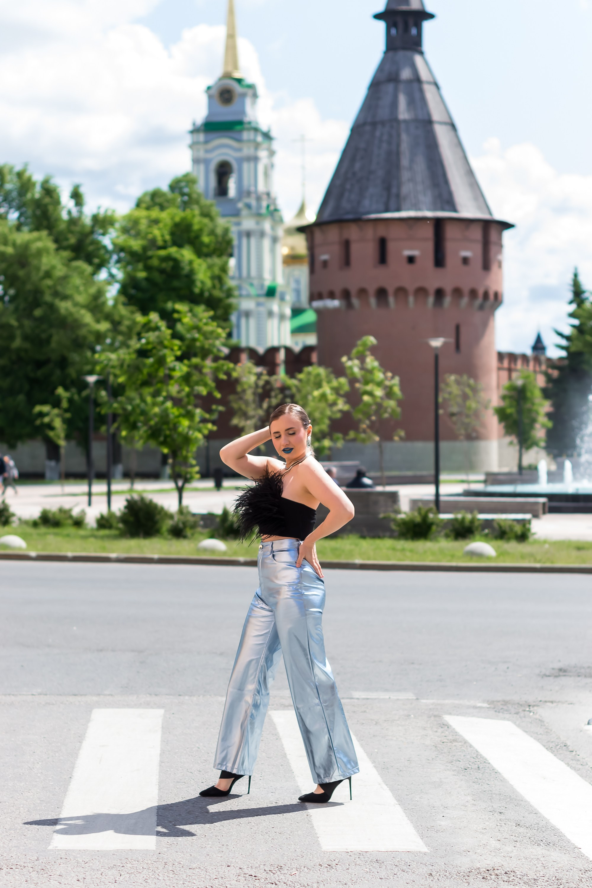 На фотографии девушка идет по улице.