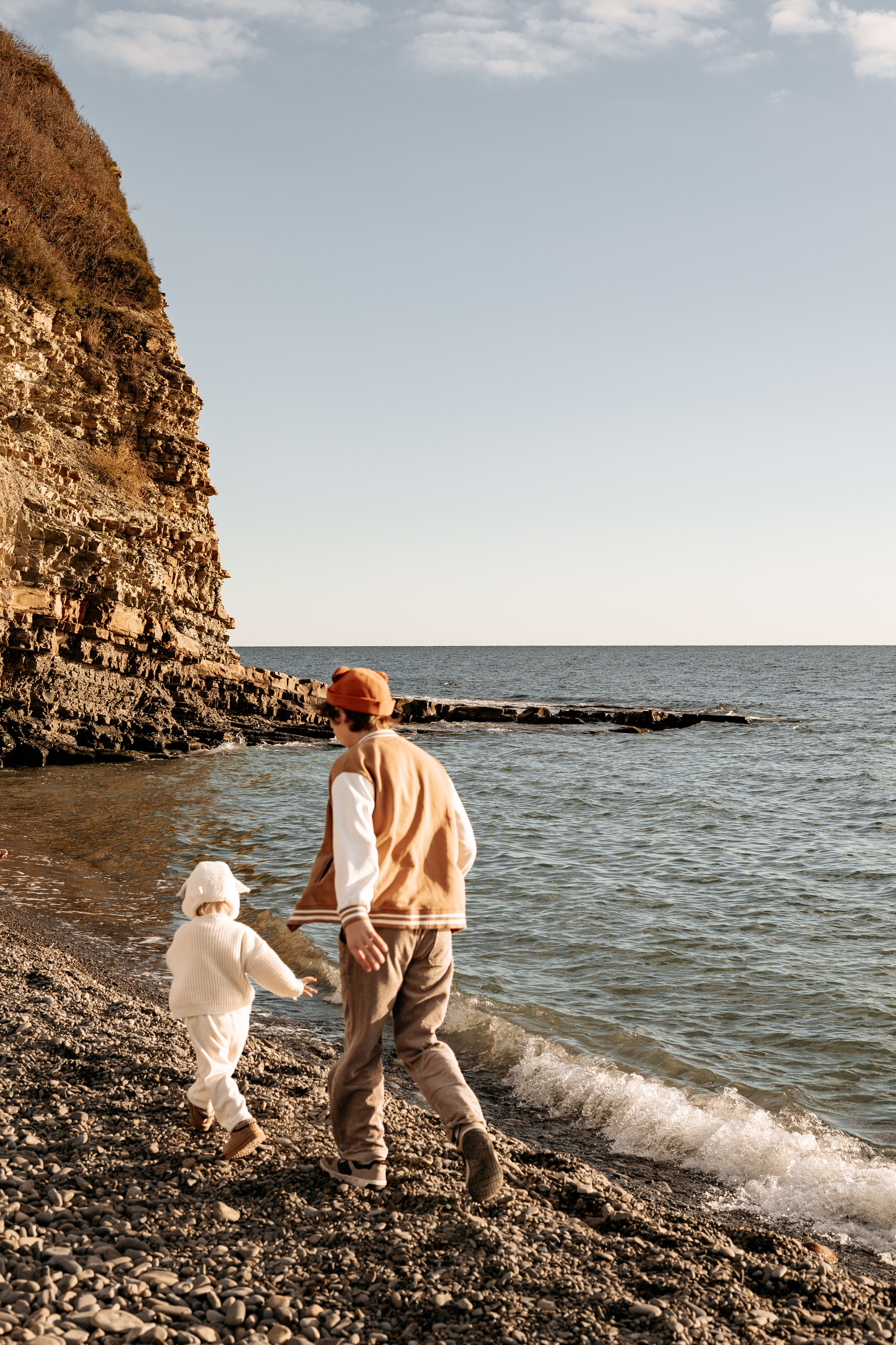 Дети радостно бегут по кромке воды на закате
