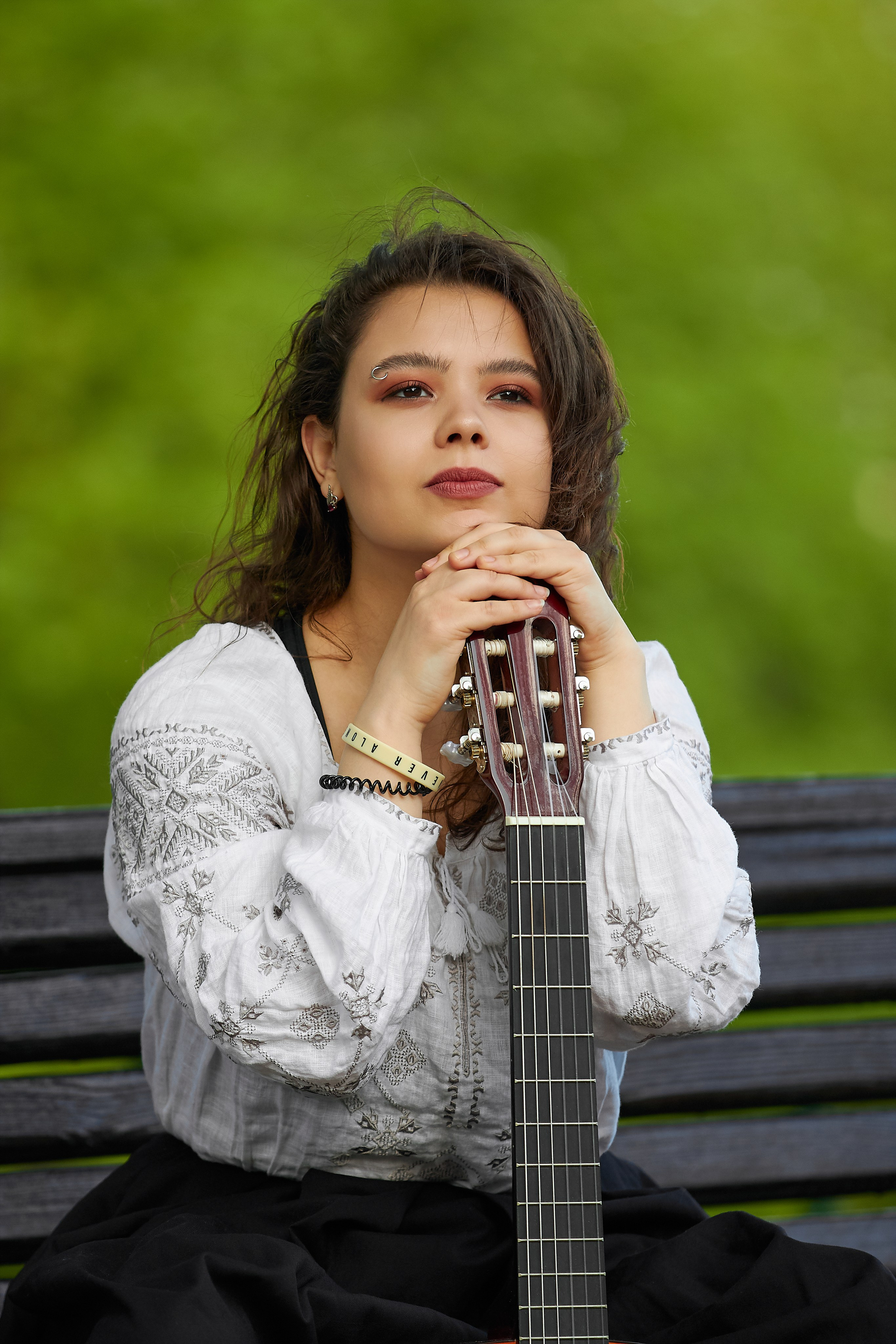 Alt-текст - Крупный план: девушка с гитарой на фоне цветущих деревьев в Царицыно, атмосферный портрет на природе