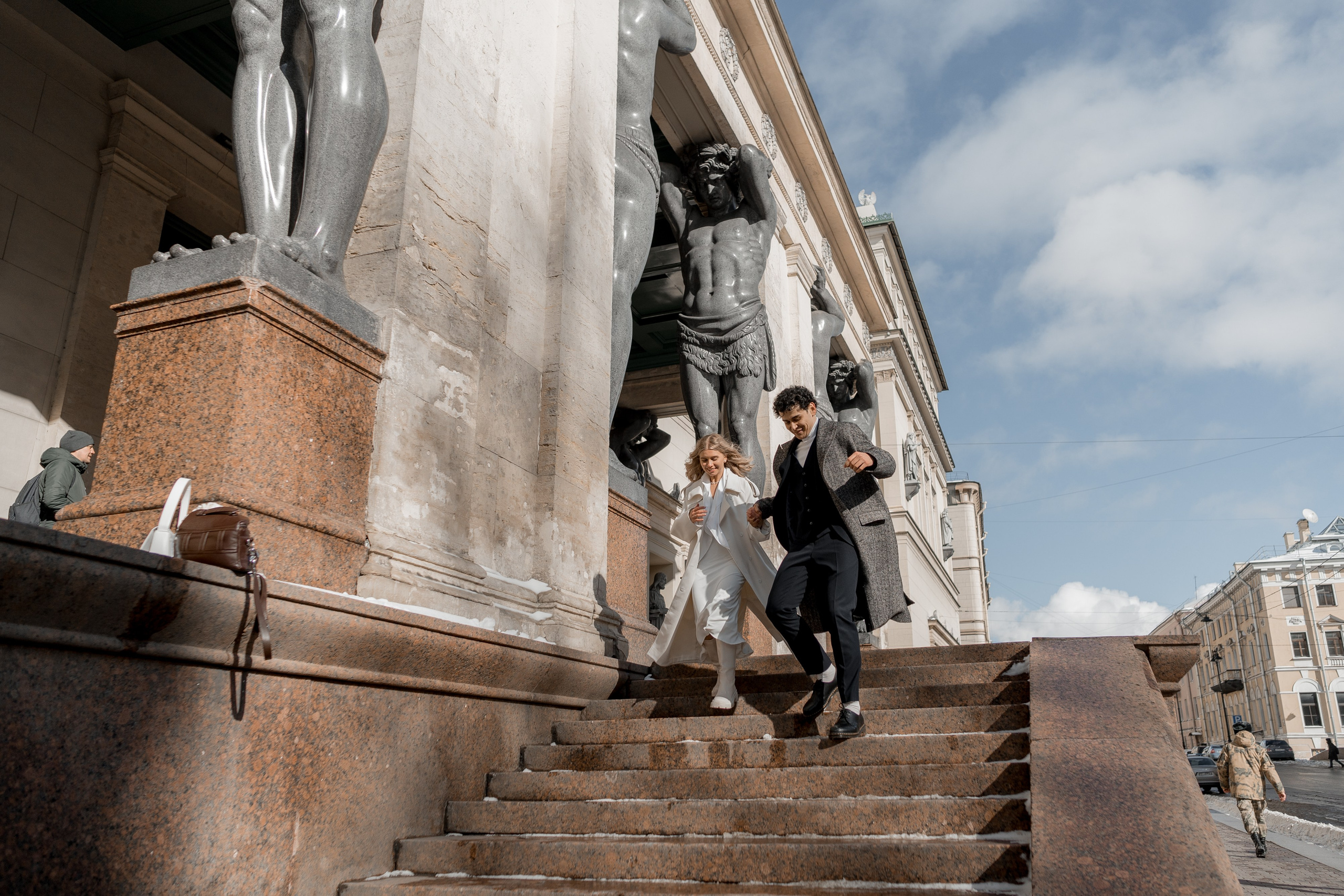 жених и невеста бегут по лестнице у атлантов эрмитажа