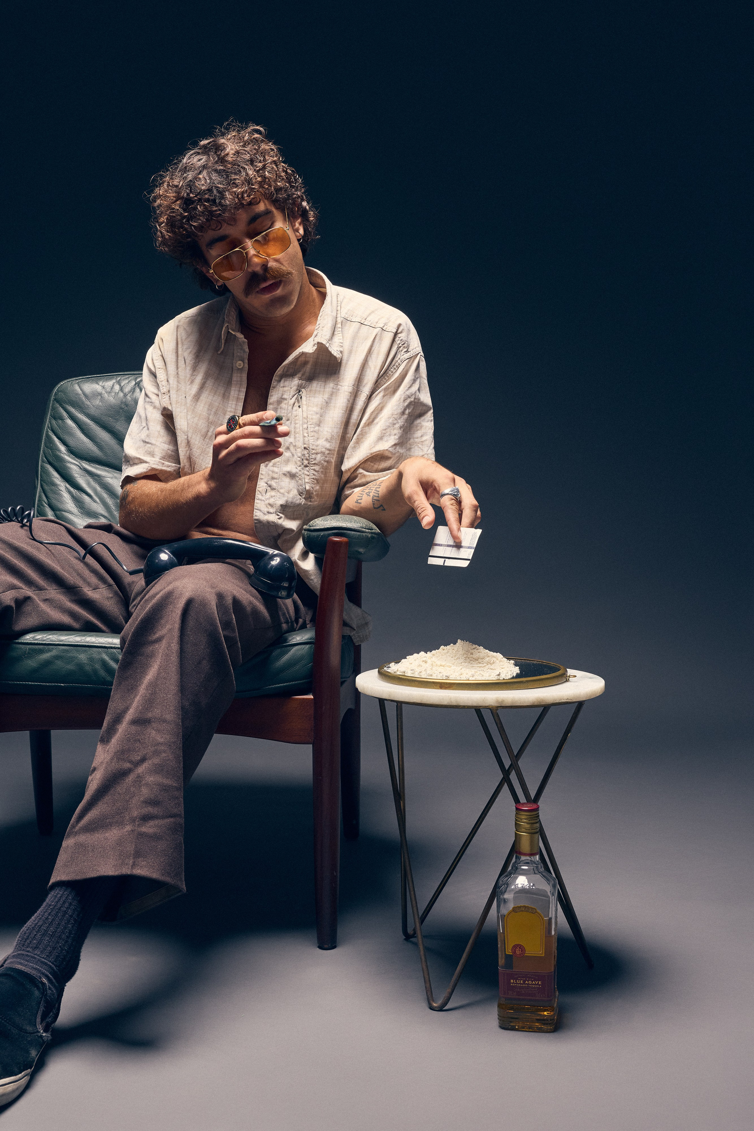 Dramatic editorial portrait of man in chair with retro look