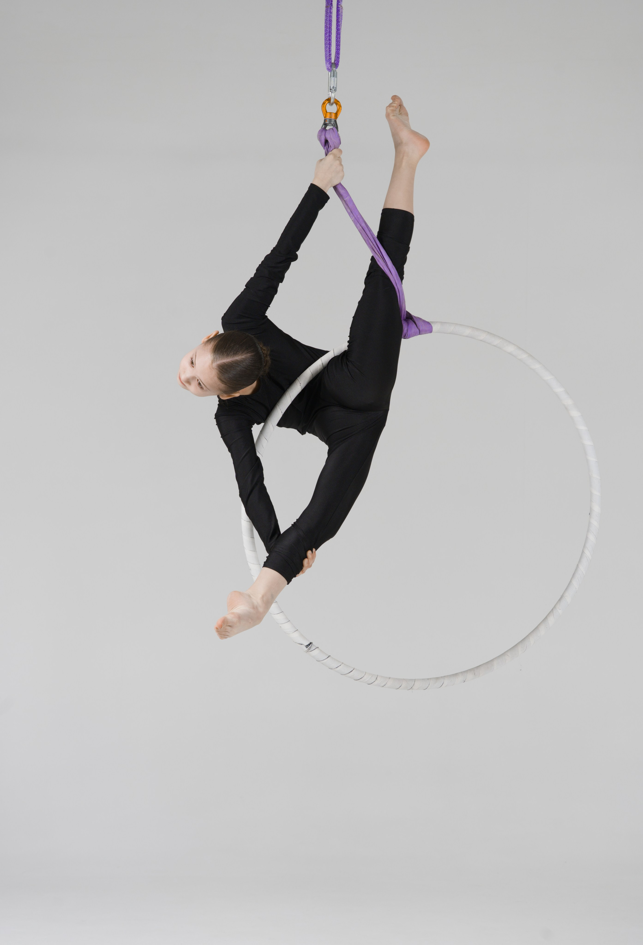 Выполнение вертикального шпагата на воздушном кольце, безупречные линии и контроль тела гимнастки