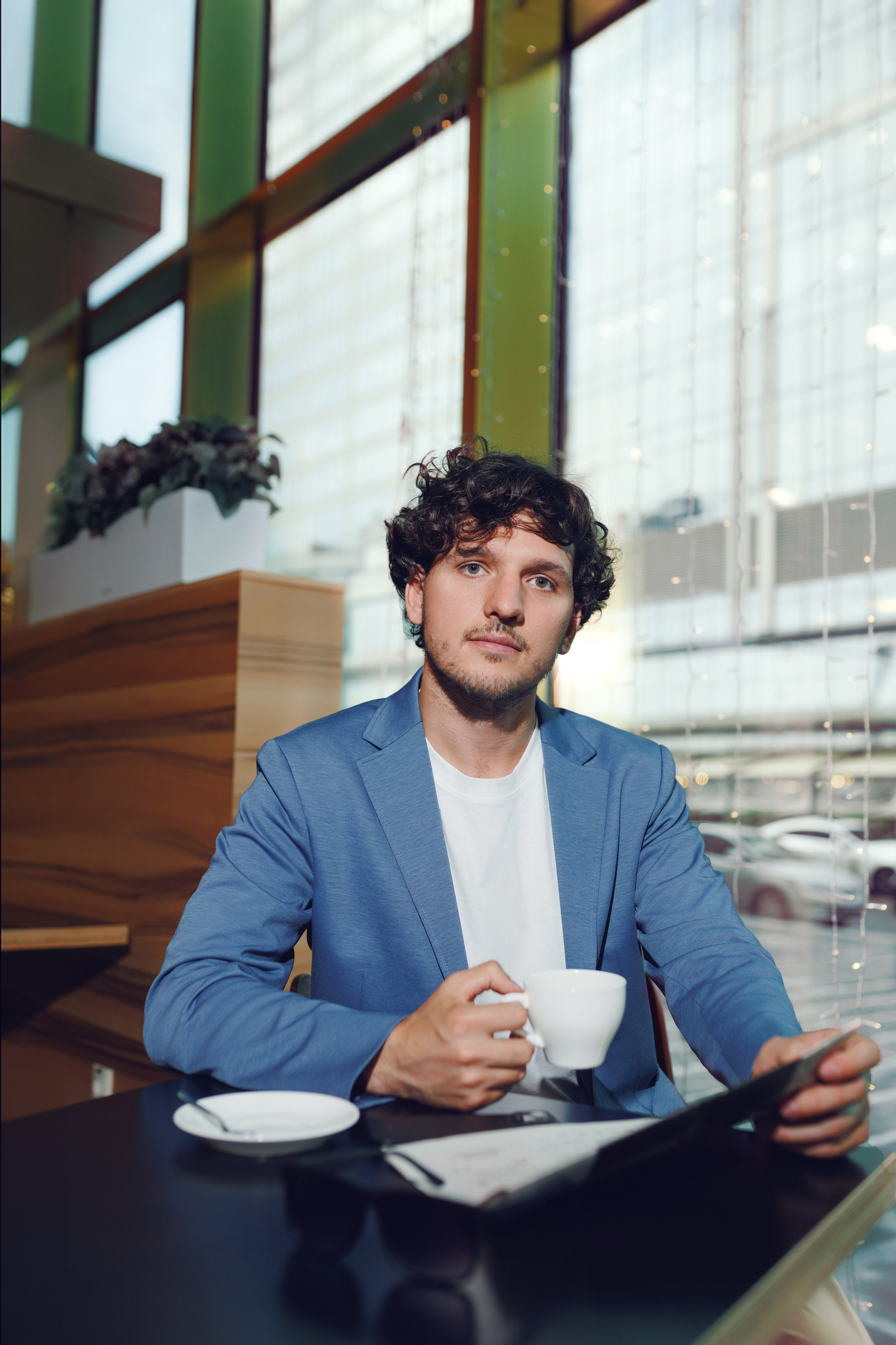Бизнесмен за чашкой кофе в кафе с панорамным видом на Москва-Сити. Деловая лайфстайл-съёмка. Фотограф Василий Жуков.