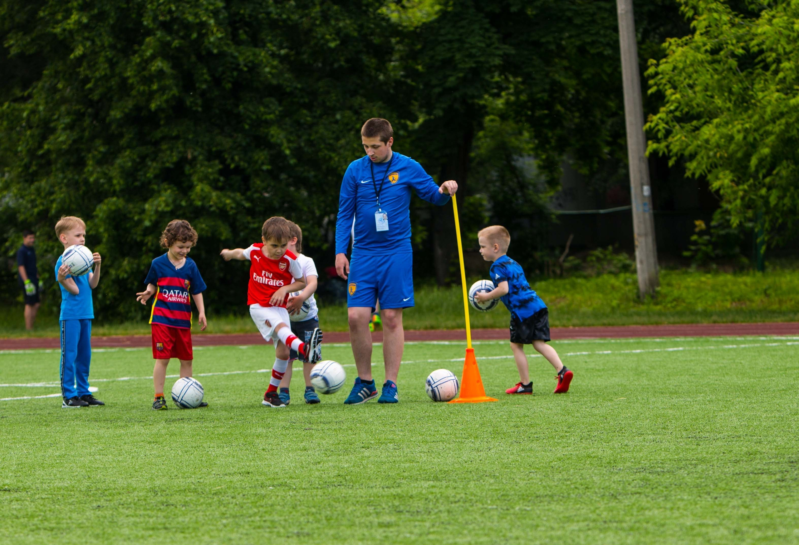 Дети 4–12 лет тренируются на футбольном поле в школе «Юниор»