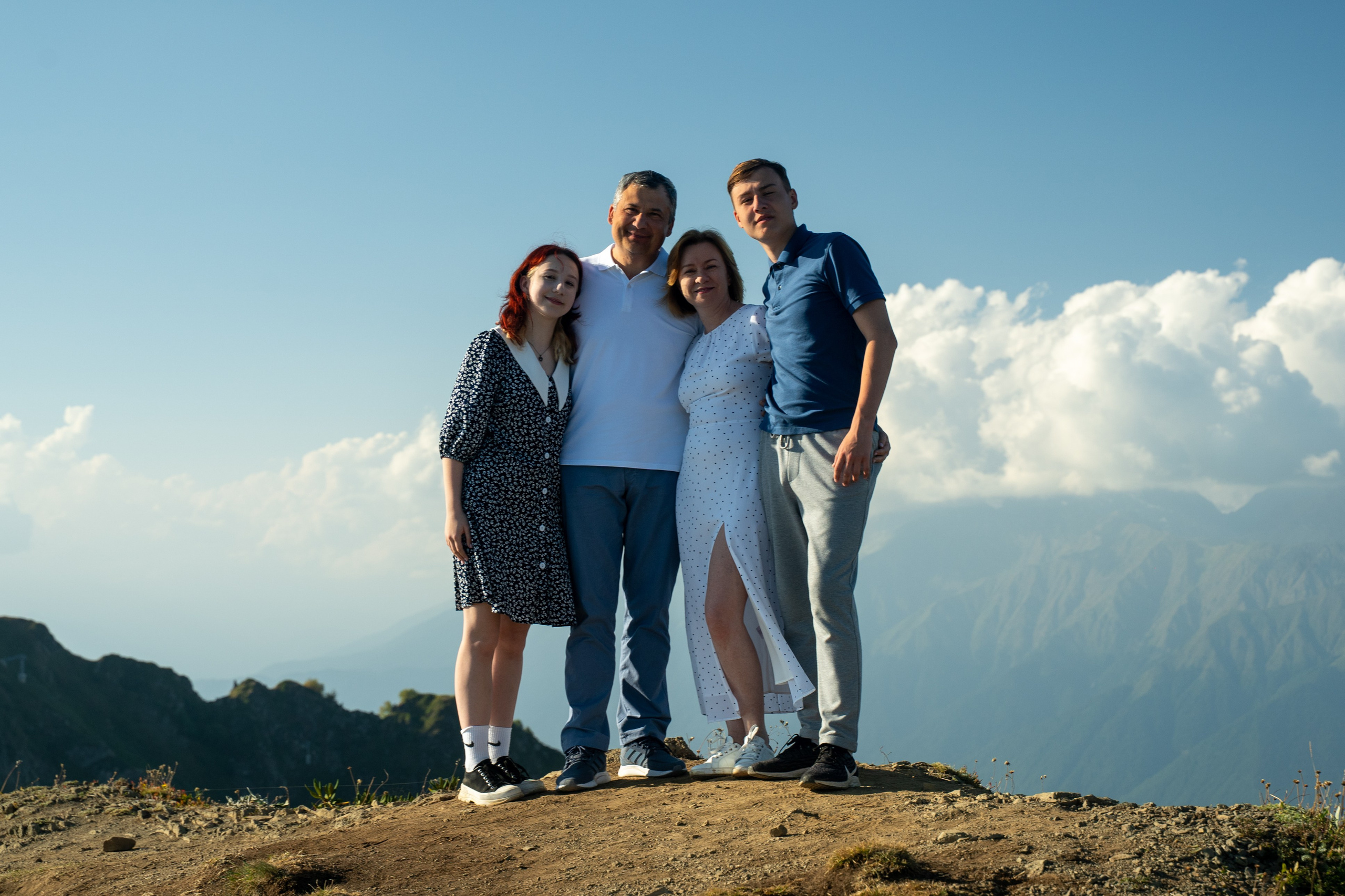 В полный рост фотокадр семьи на фоне гор