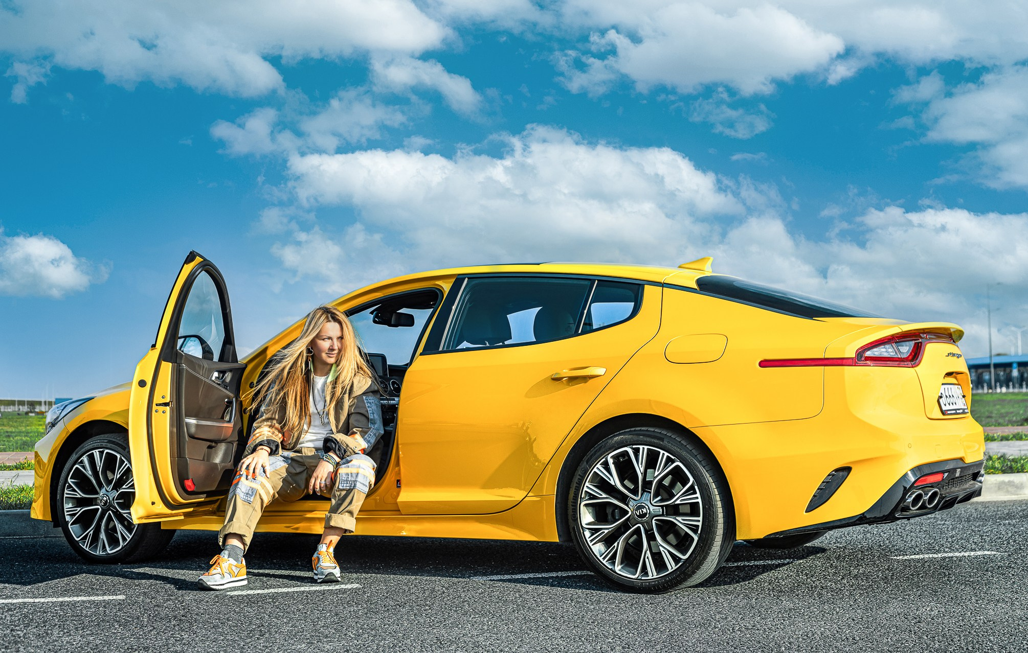 Девушка в военных джинсах в машине Kia Sportage.