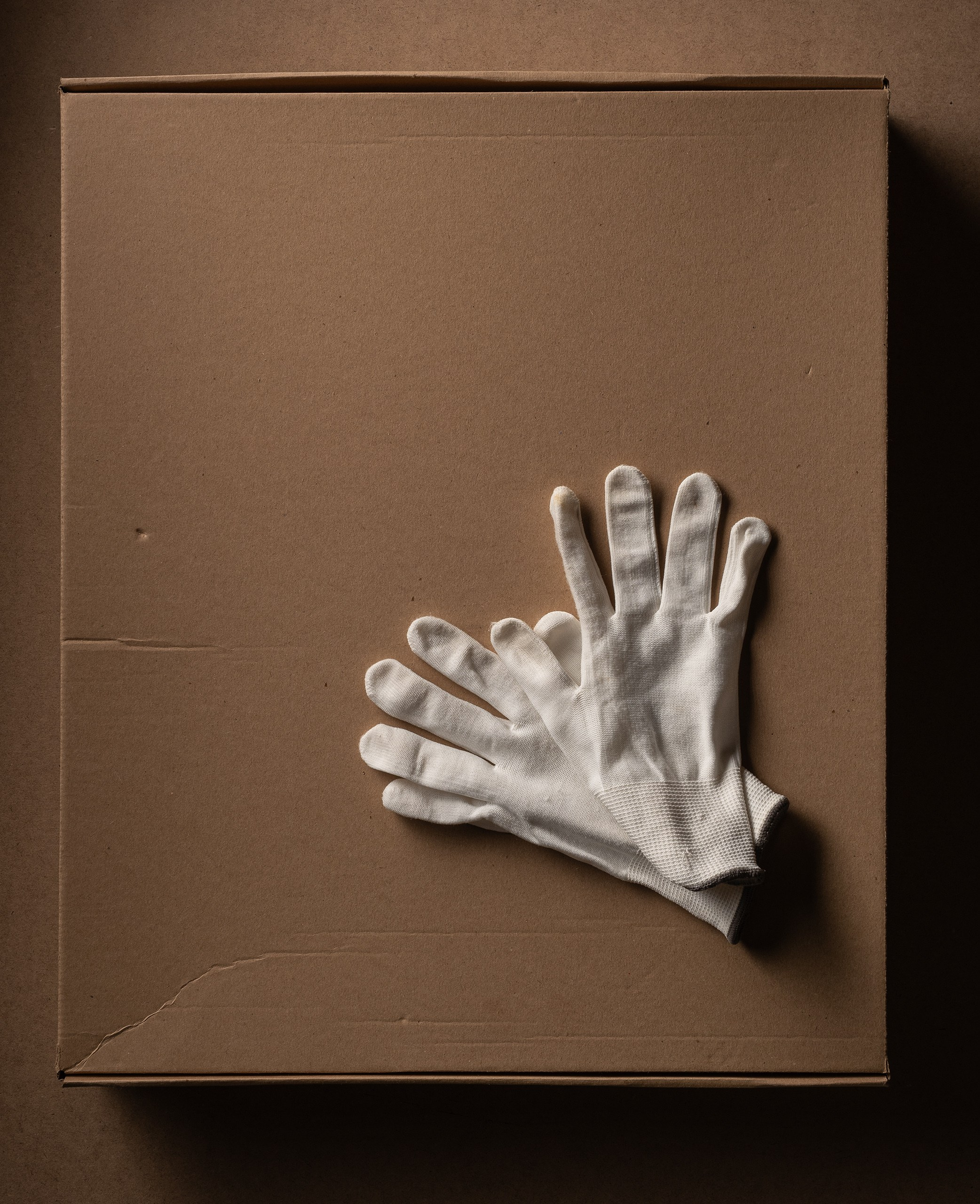 Белые перчатки на картонной коробке. 
