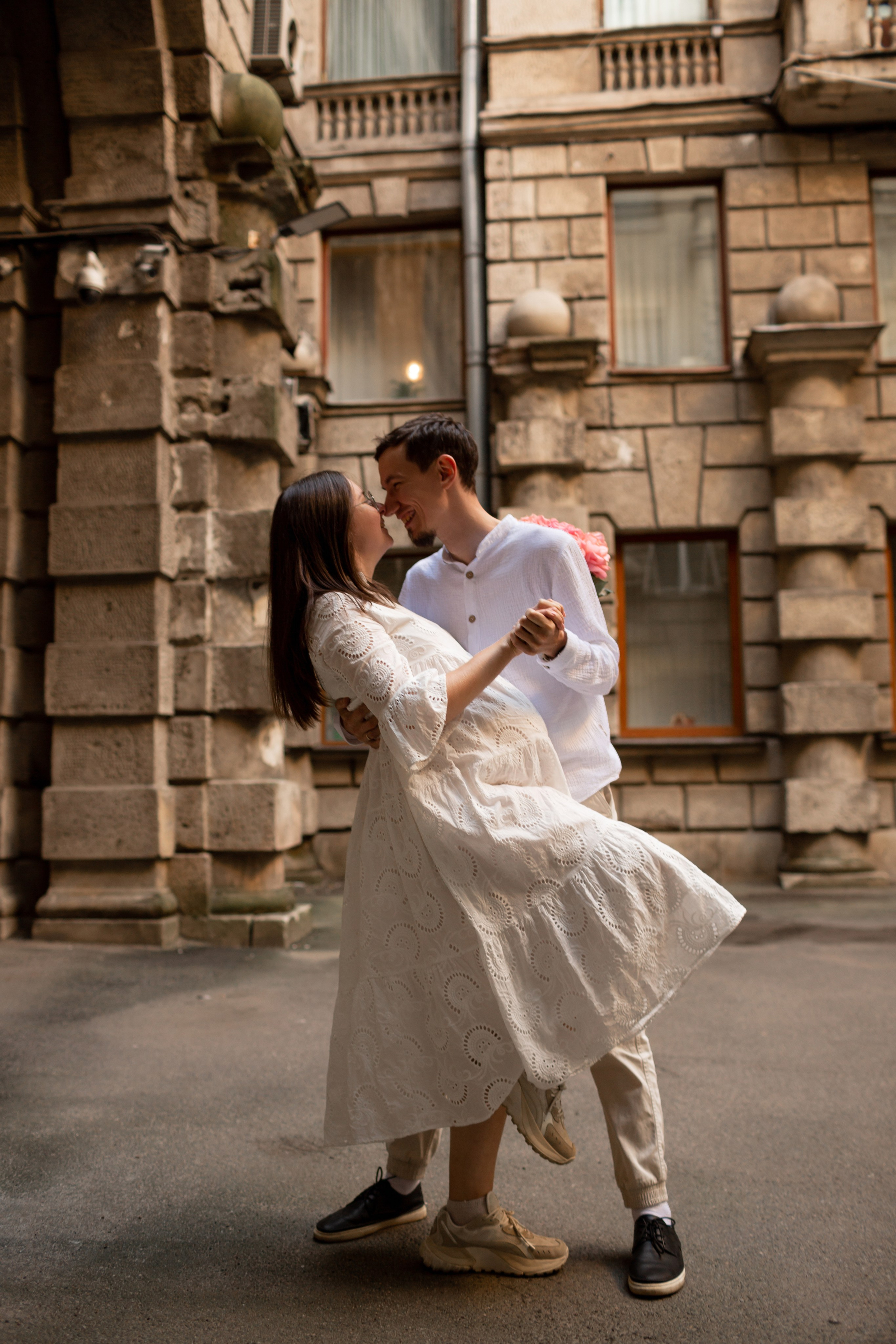 Молодая пара прогуливается по двору Петербурга.