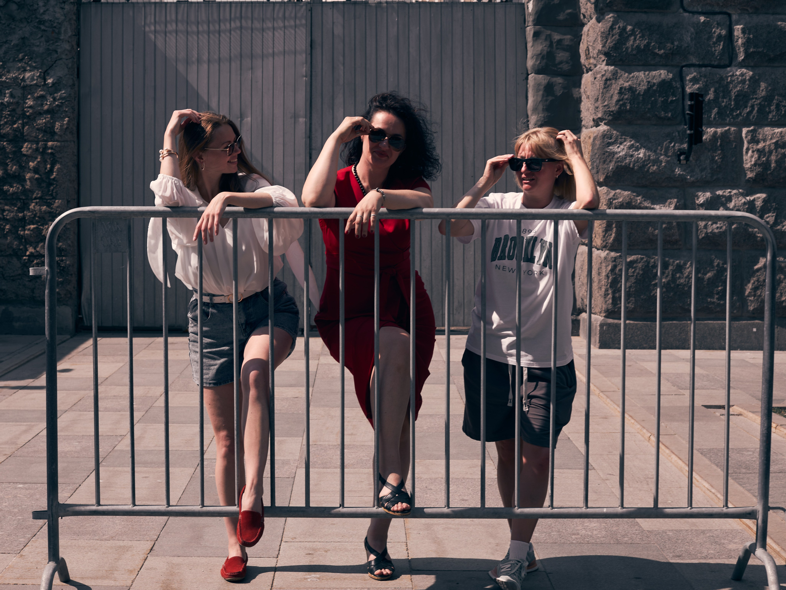 Три девушки стоят и смеются на улице