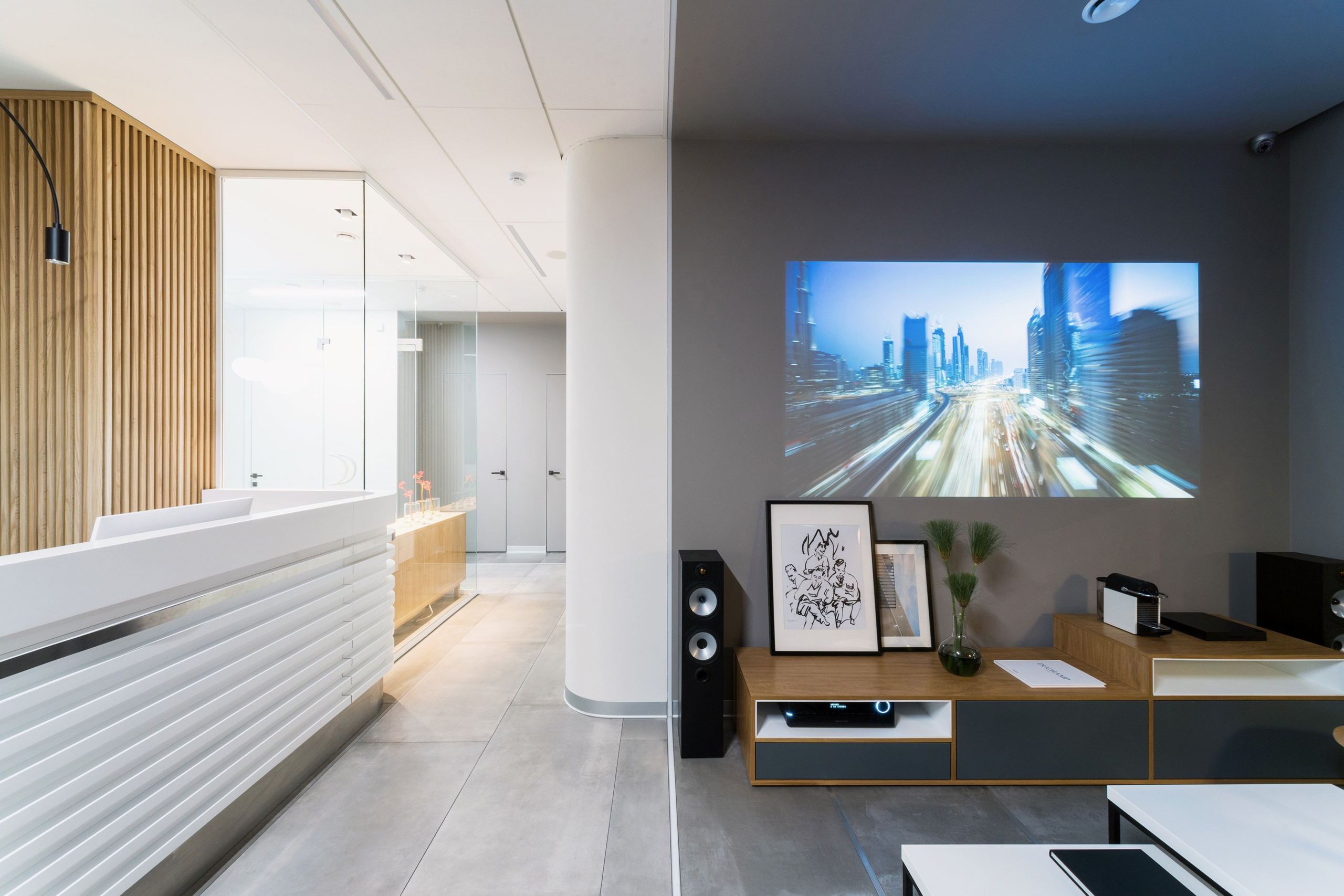 дизайн интерьера стоматологической клиники выполнен в современном минималистичном стиле с теплой домашней атмосферой. Текстуры дерева, наливной пол, яркие акценты, чистота линий, модульная сетка, стеклянные перегородки