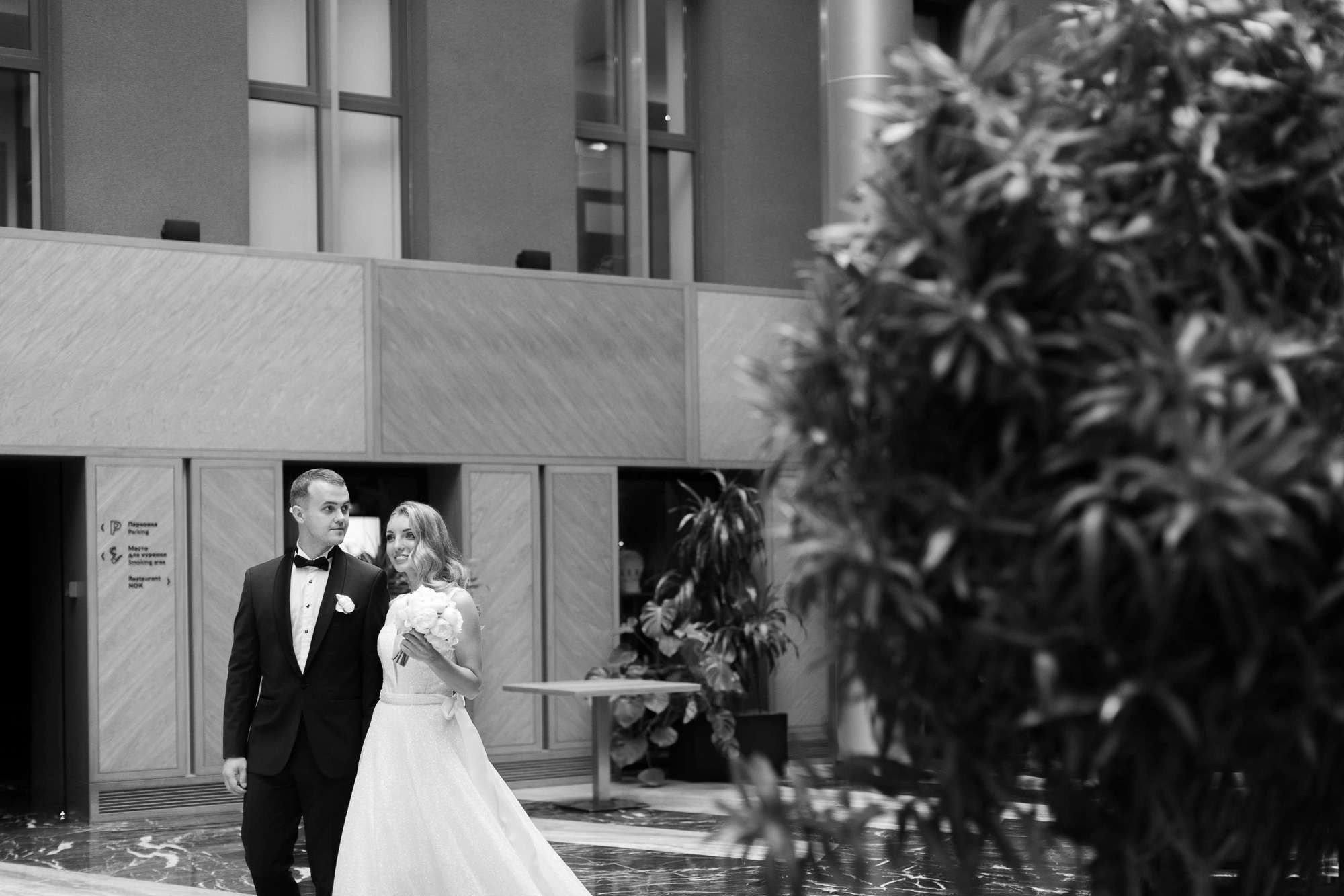 Жених и невеста идут в холле отеля Гамма