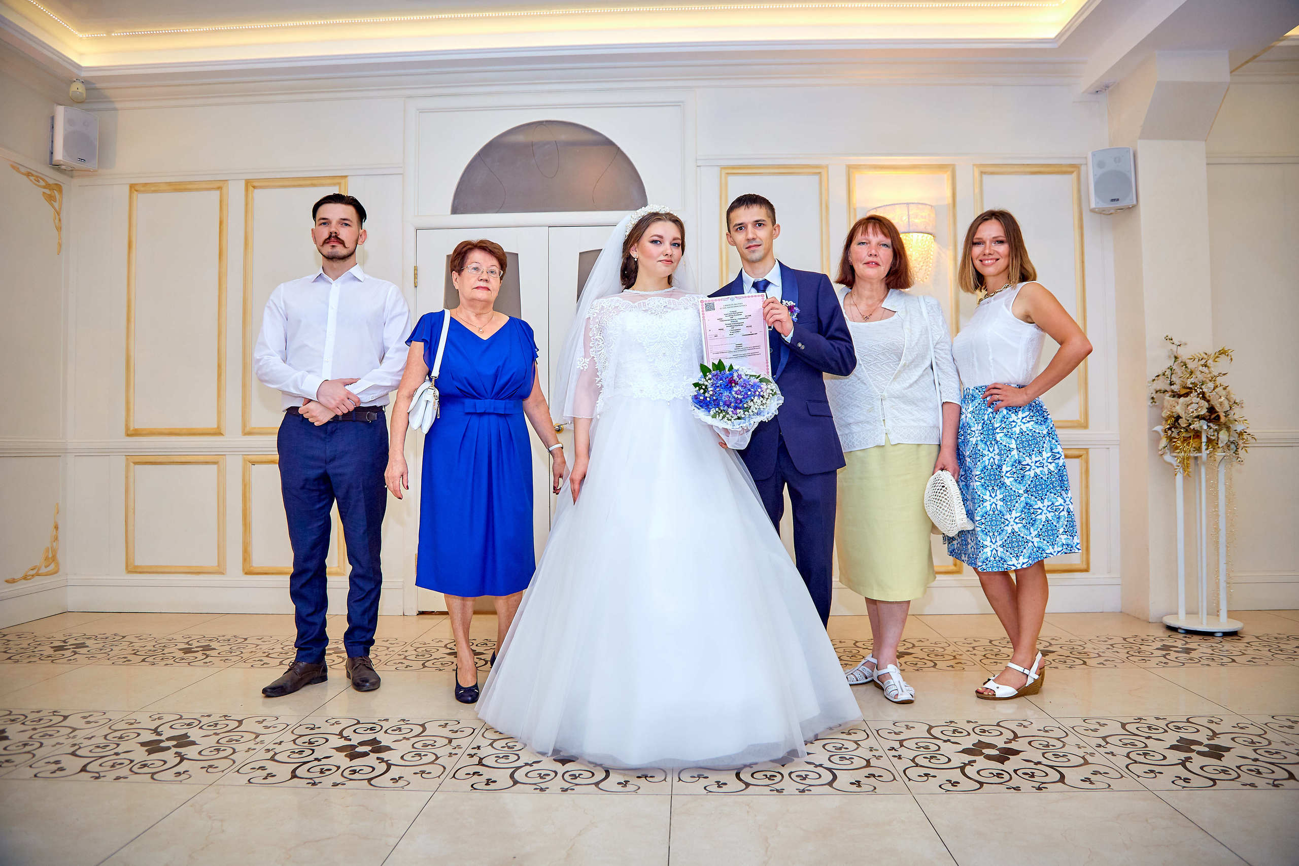 Жених и невеста в ЗАГСе с гостями