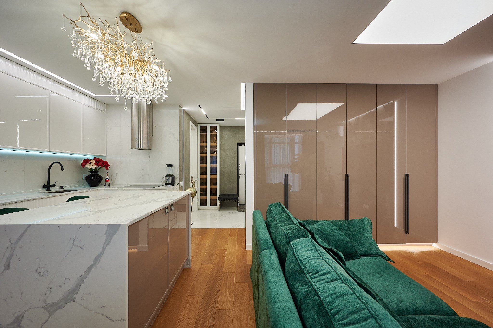 зеленый диван  кухня белые шкафы плитка светлая 