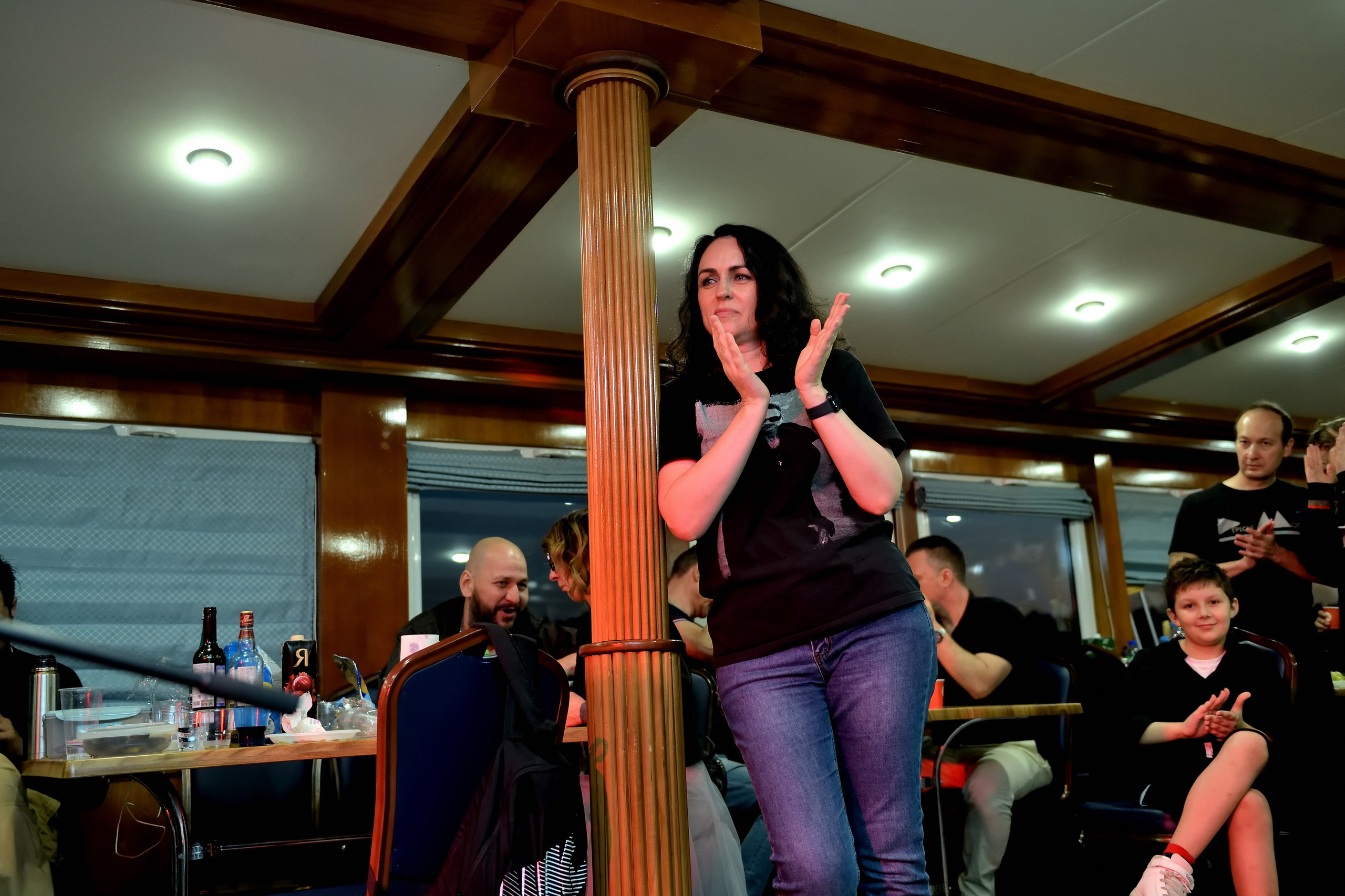 "Зрительница аплодирует музыкантам на концерте".