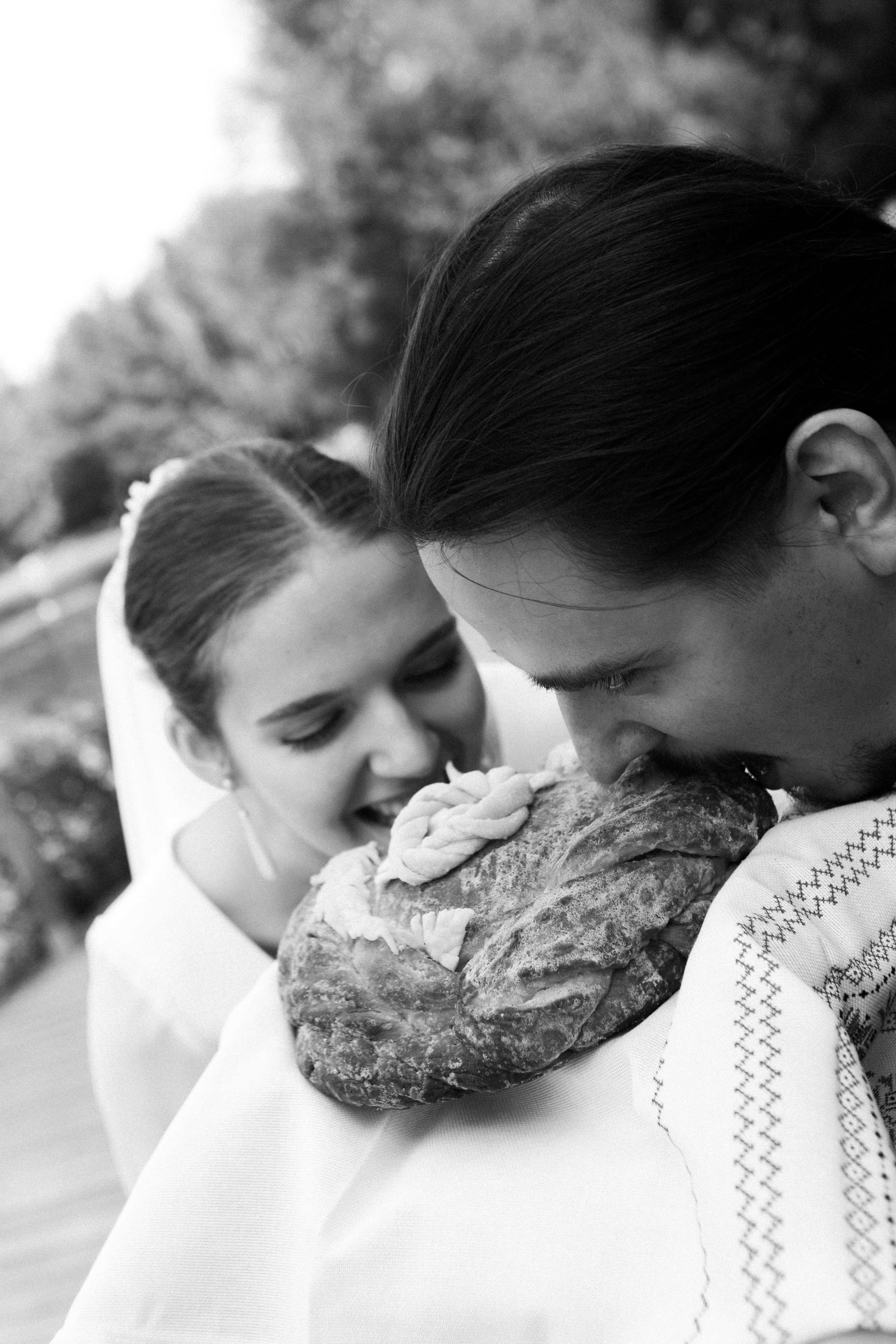 свадебные традиции, жених и невеста кусают каравай, свадебная церемония на открытом воздухе, свадебный фотограф в Москве