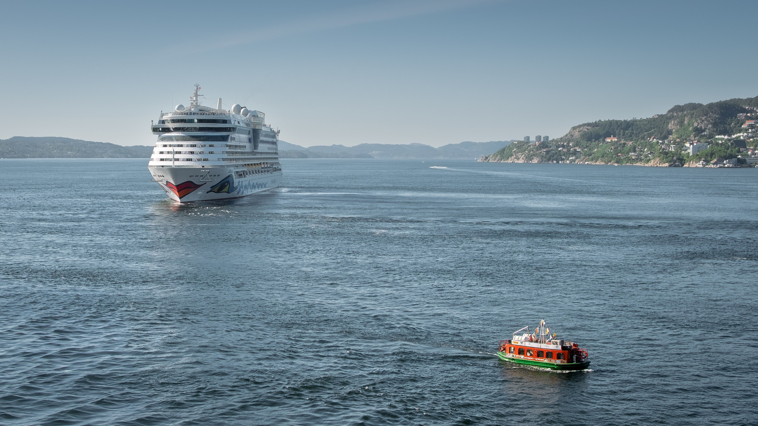Вид на красивый фьорд с океанским лайнером и маленьким катером