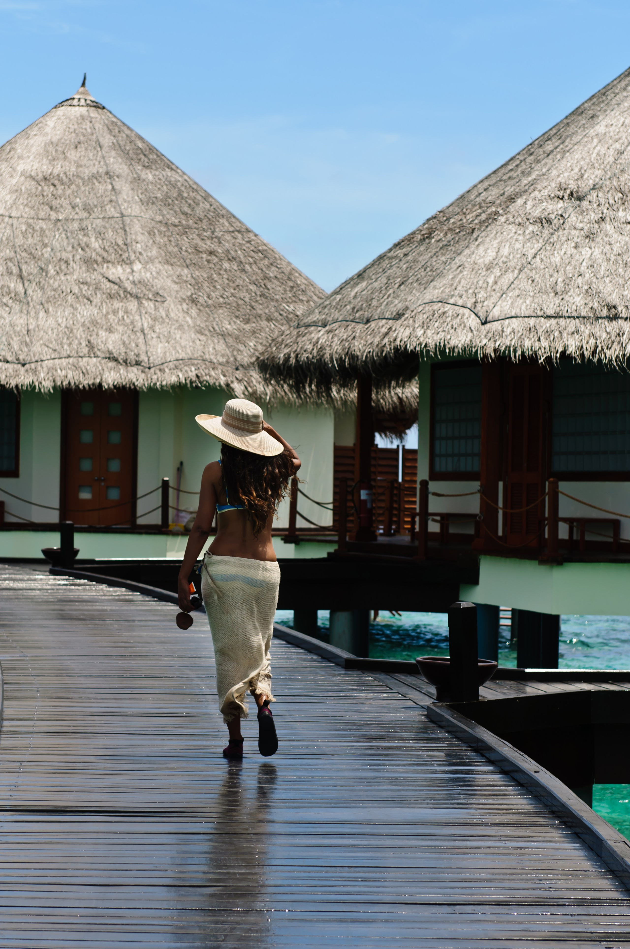 Девушка в шляпе около бунгало. Мальдивы