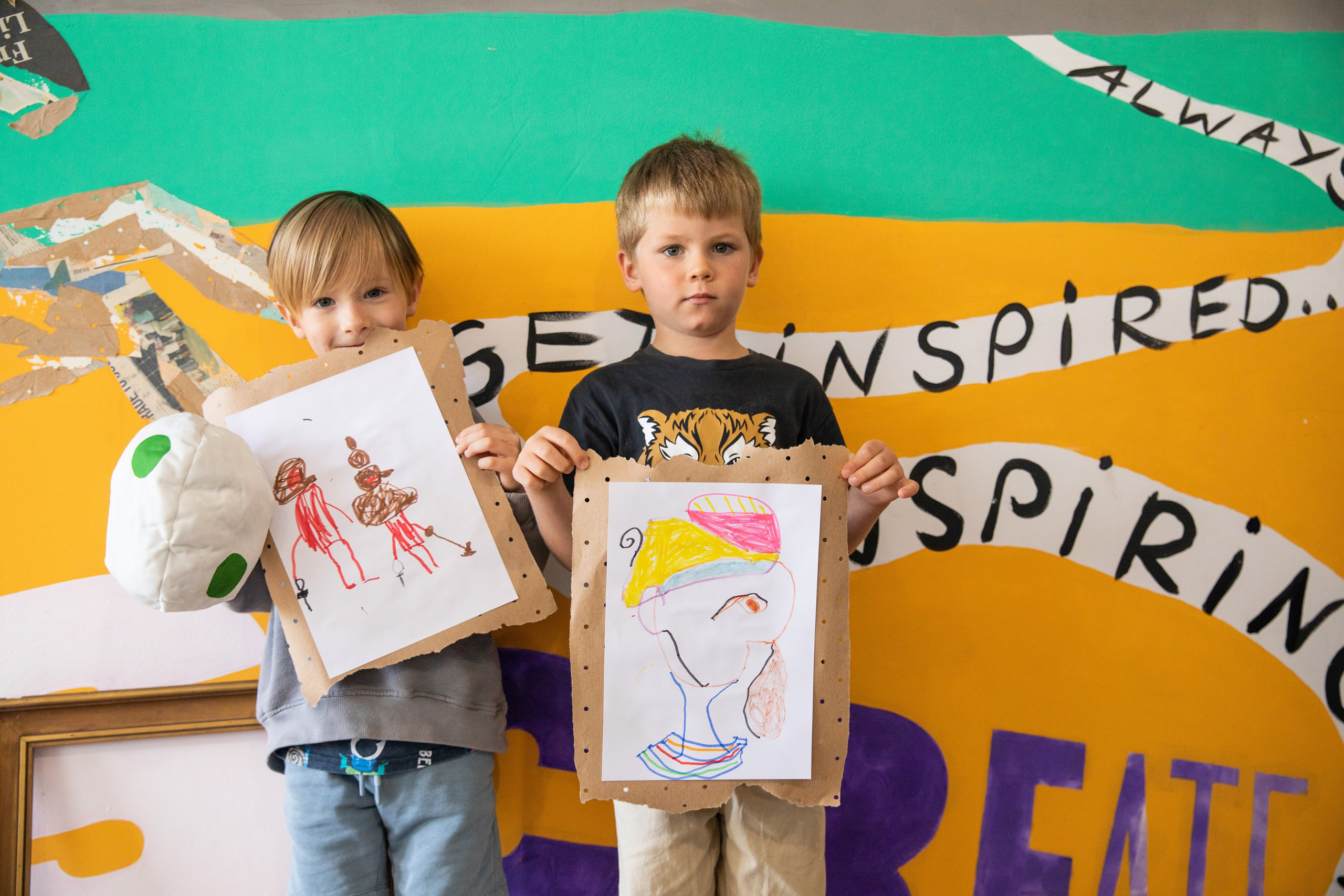 Joyful children show their drawings