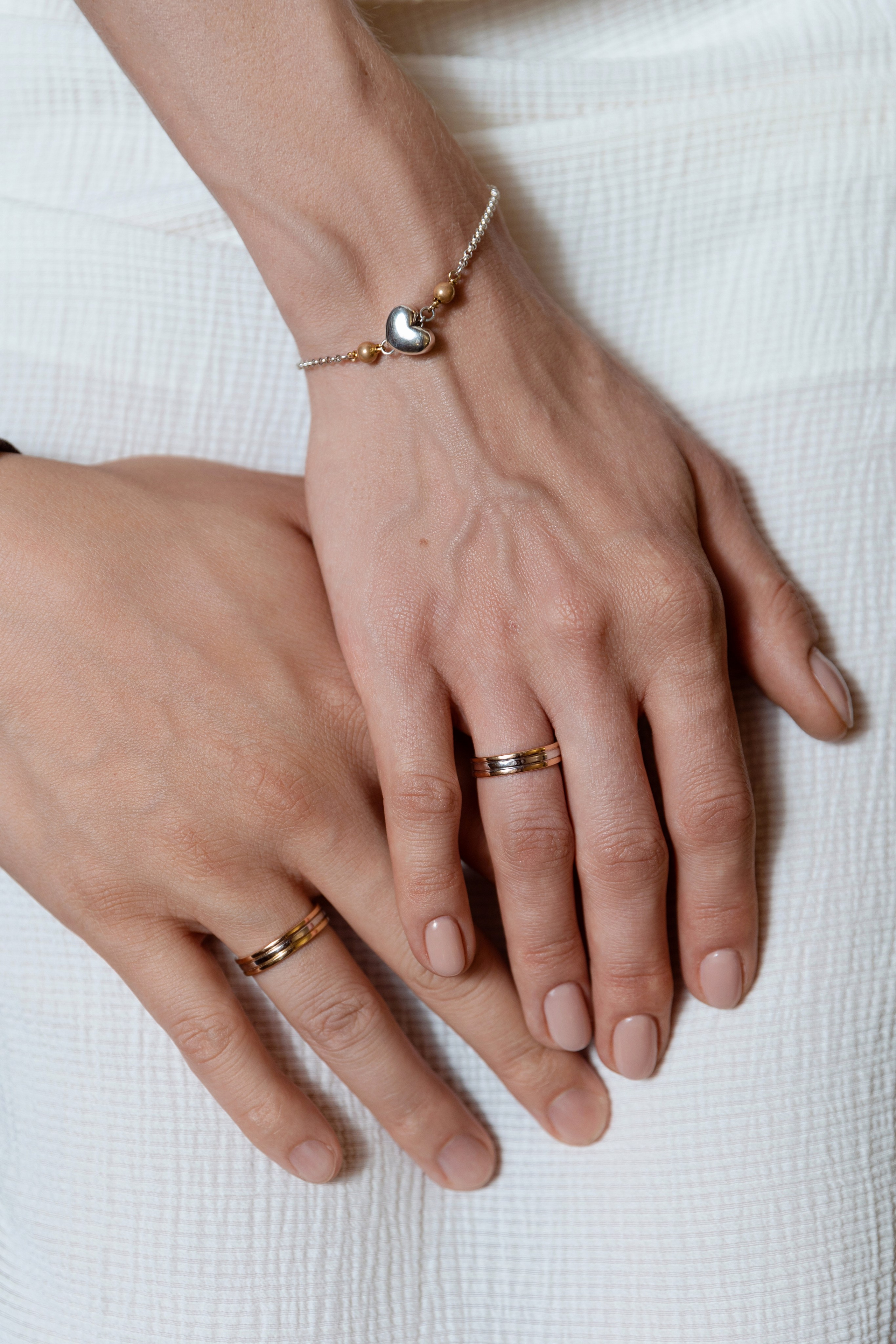 На фото руки молодоженов с обручальными кольцами.