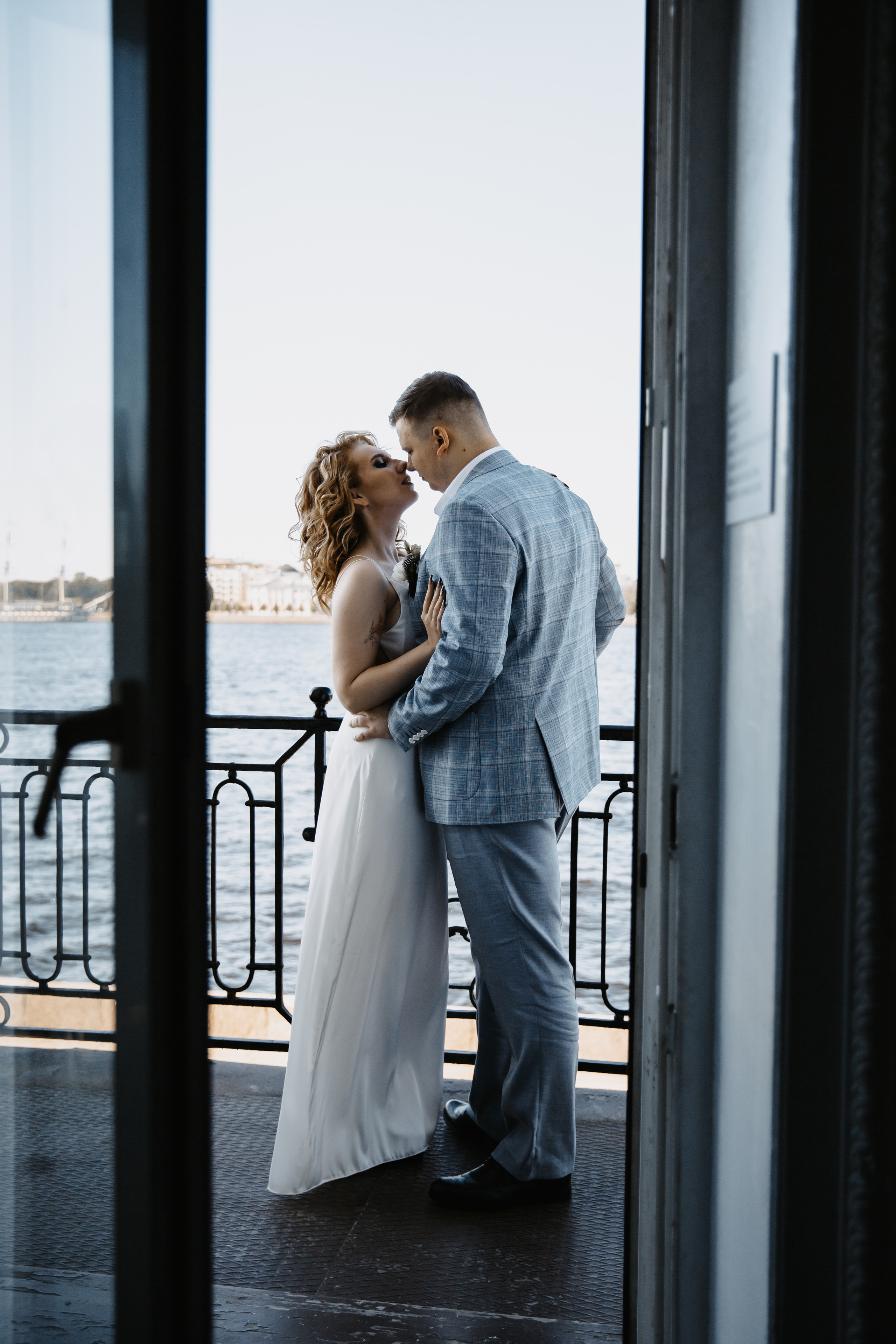 Невеста и жених обнимаются на балконе