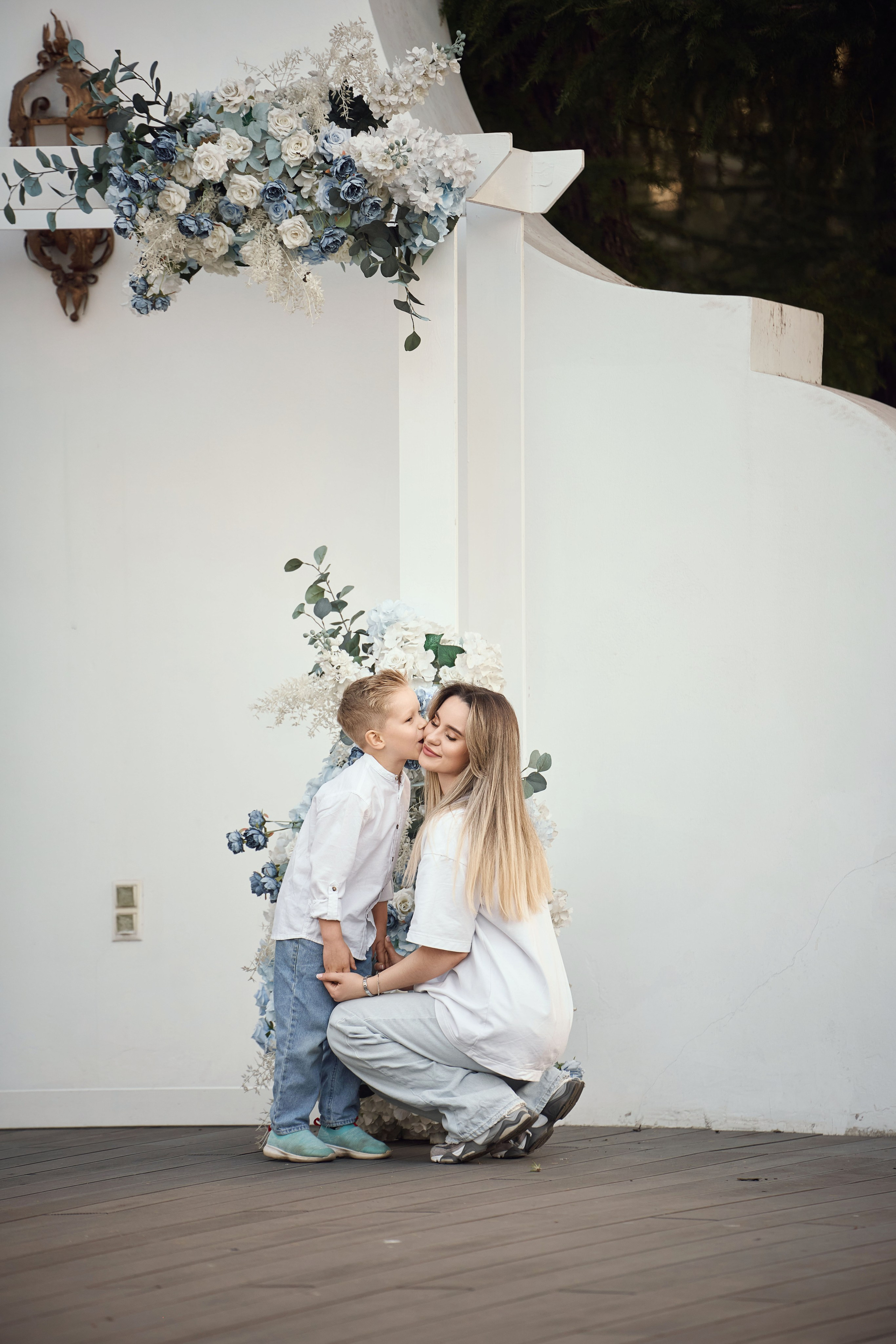 сын целует маму во время семейной фотосессии 