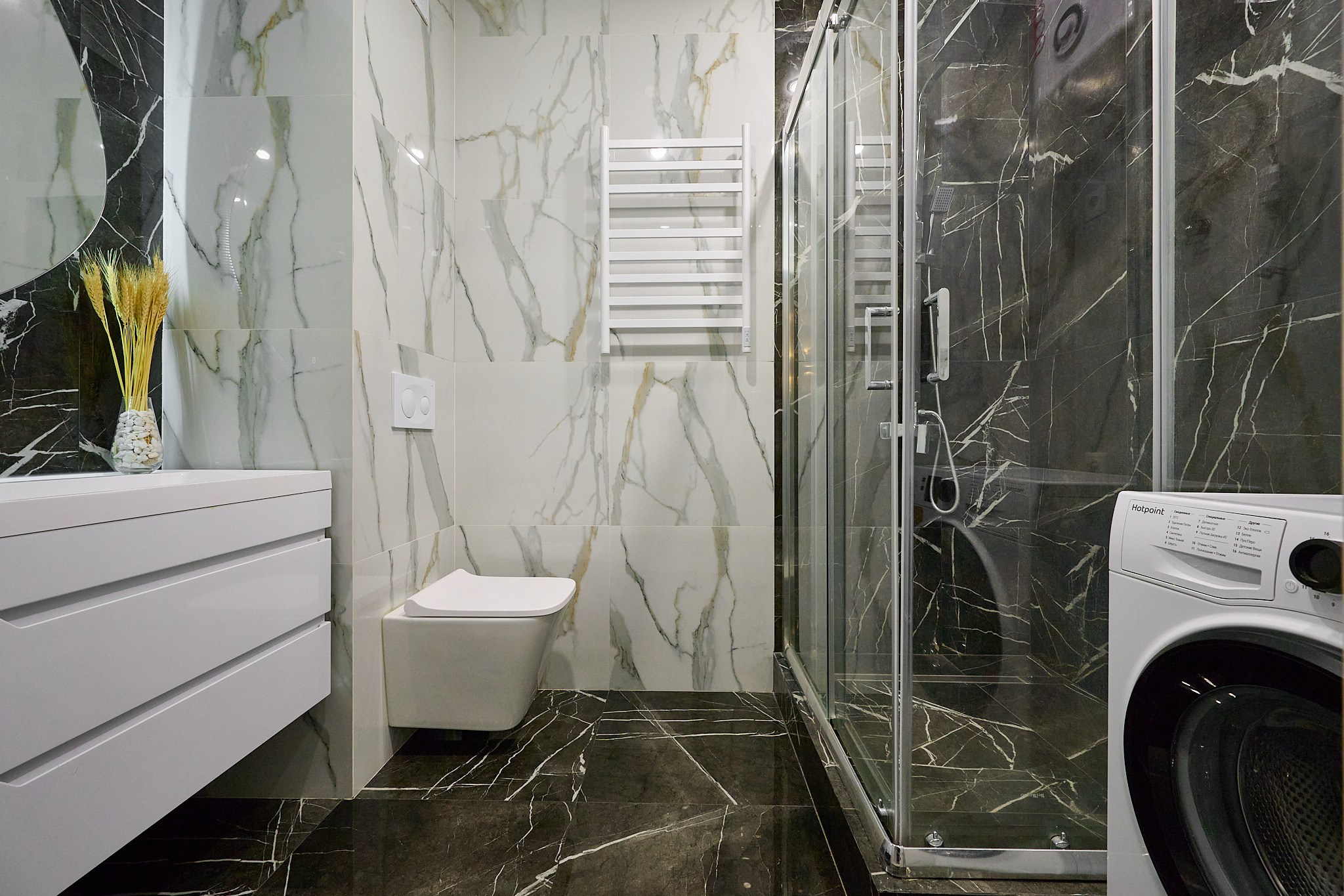 ванная комната темные плиты на полу и в душевой кабине белые полки белая раковина круглое зеркало с подсветкой 