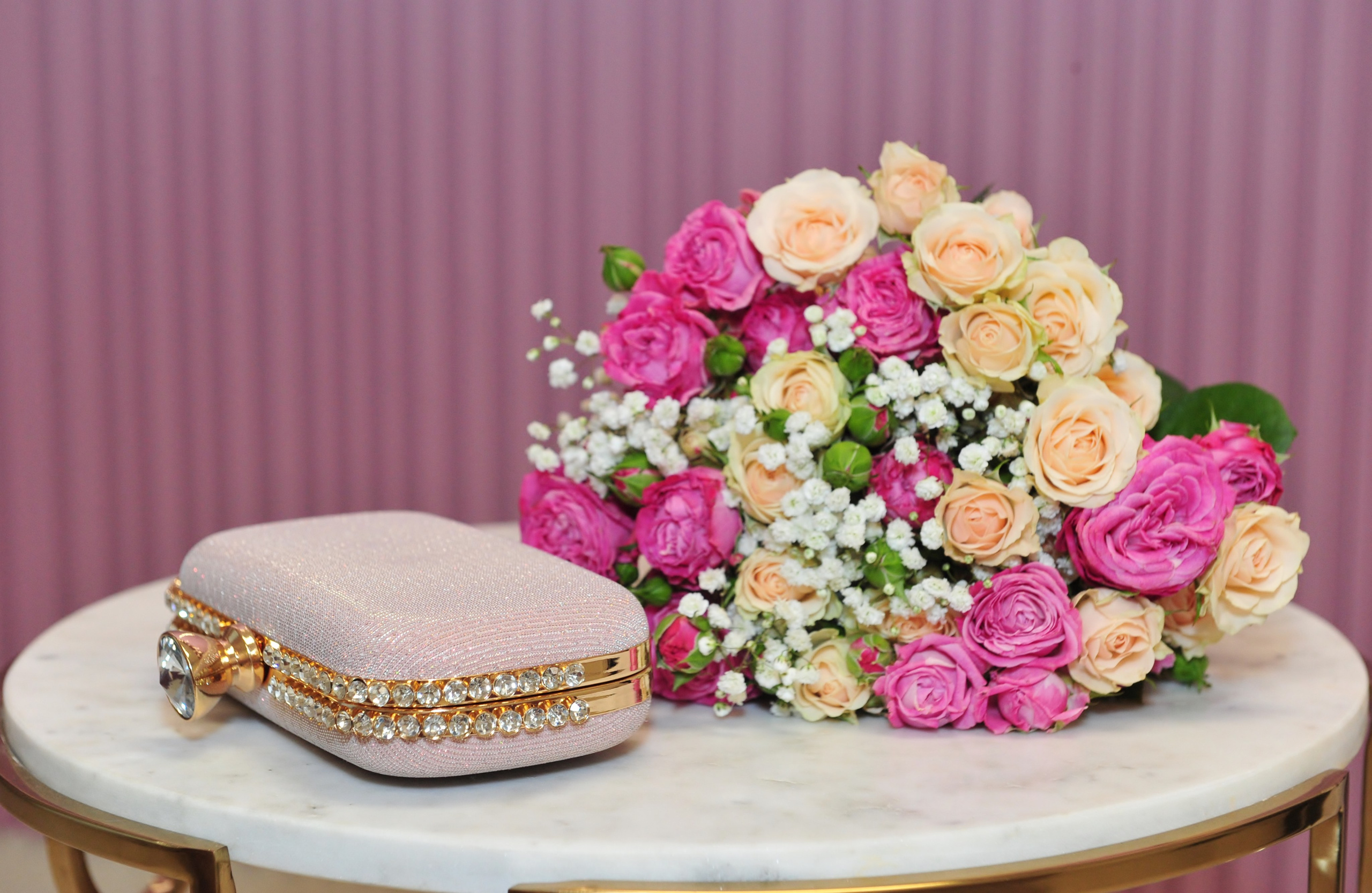 Свадьба в Царицыно пасмурным летним днем, сумочка со стразами и букет невесты на столике в ЗАГСе 