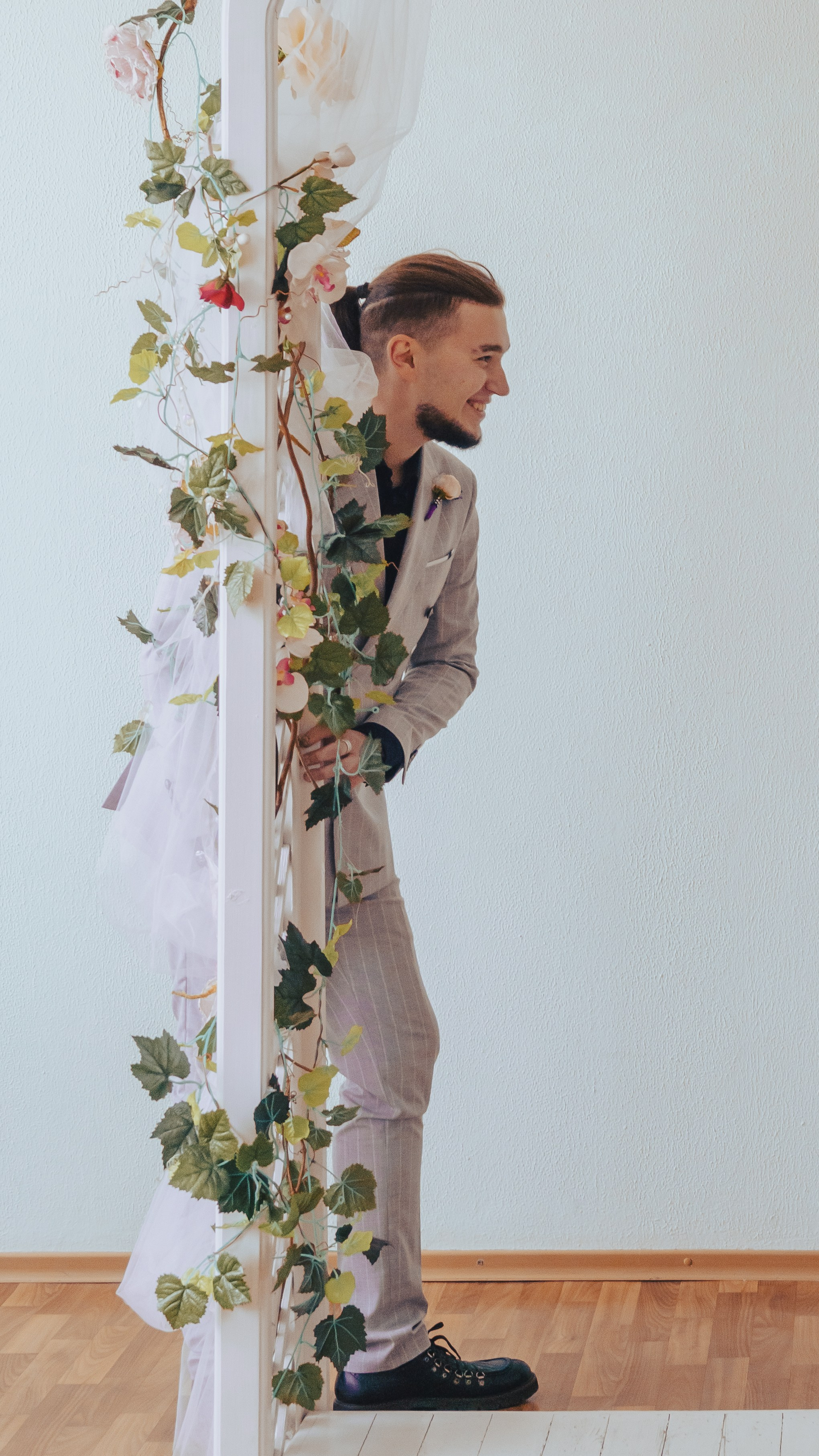 жених выглядывает из-за арки