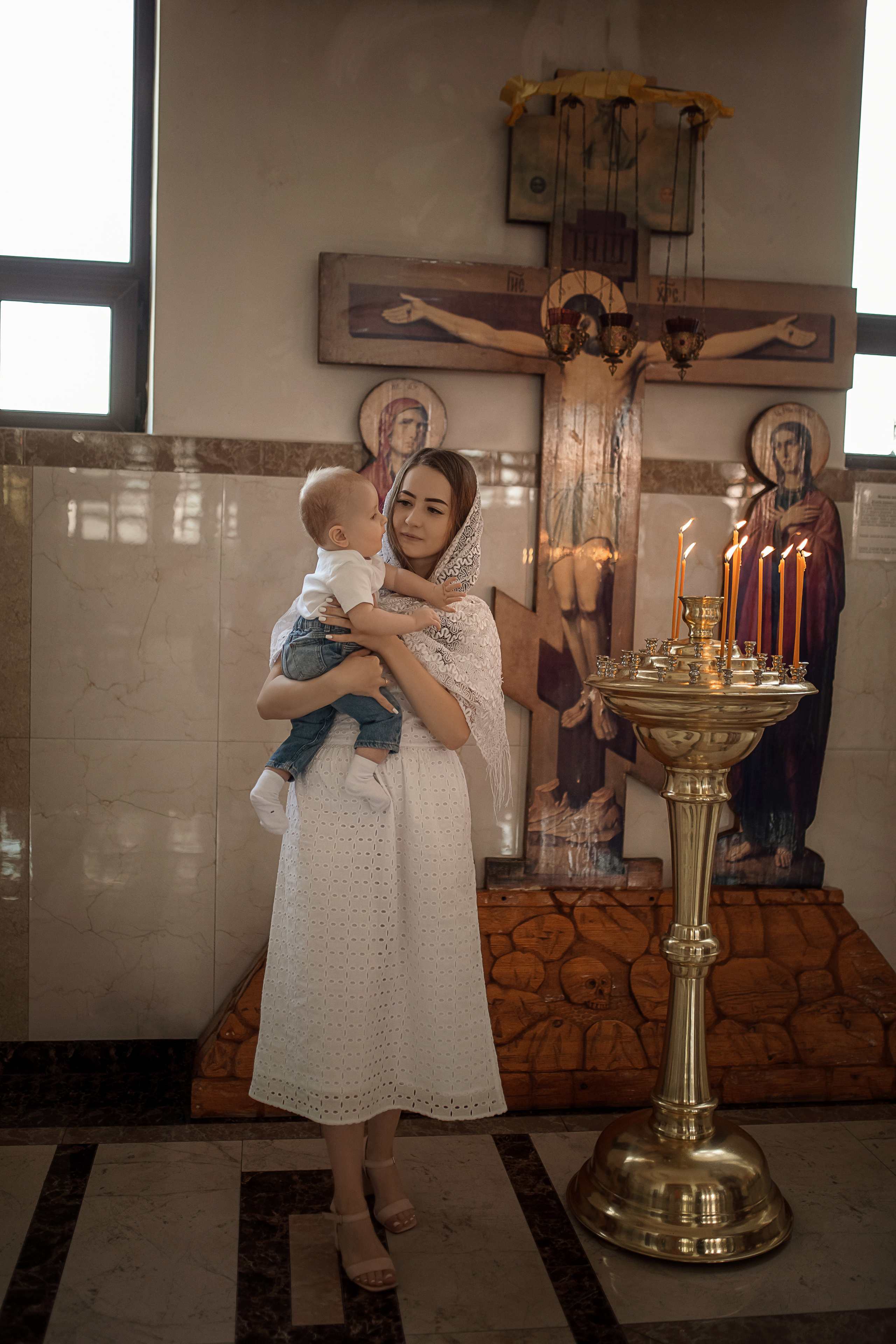 мама держит ребенка перед крестинами в Ташкенте