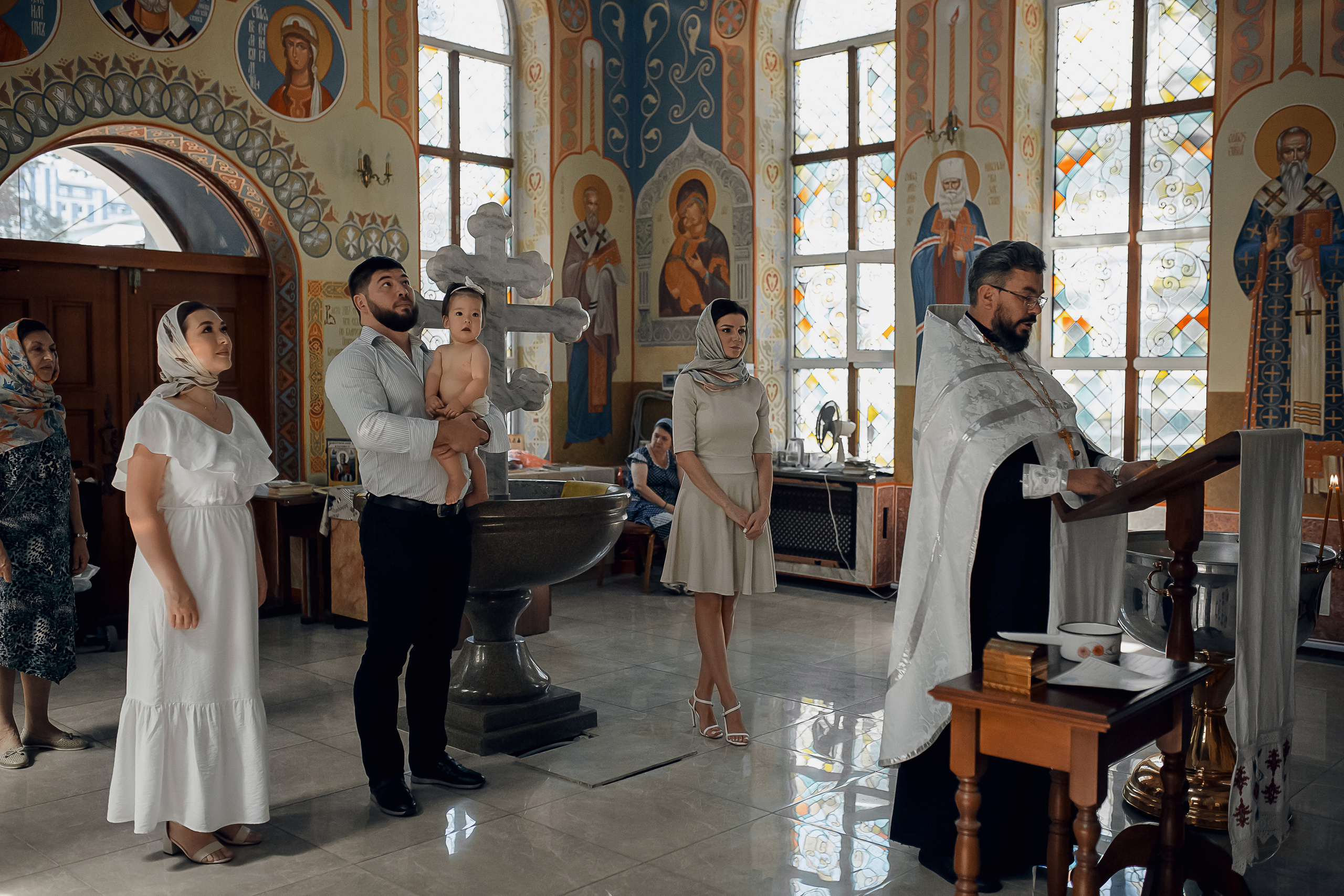 священник и семья на крещении в Ташкенте
