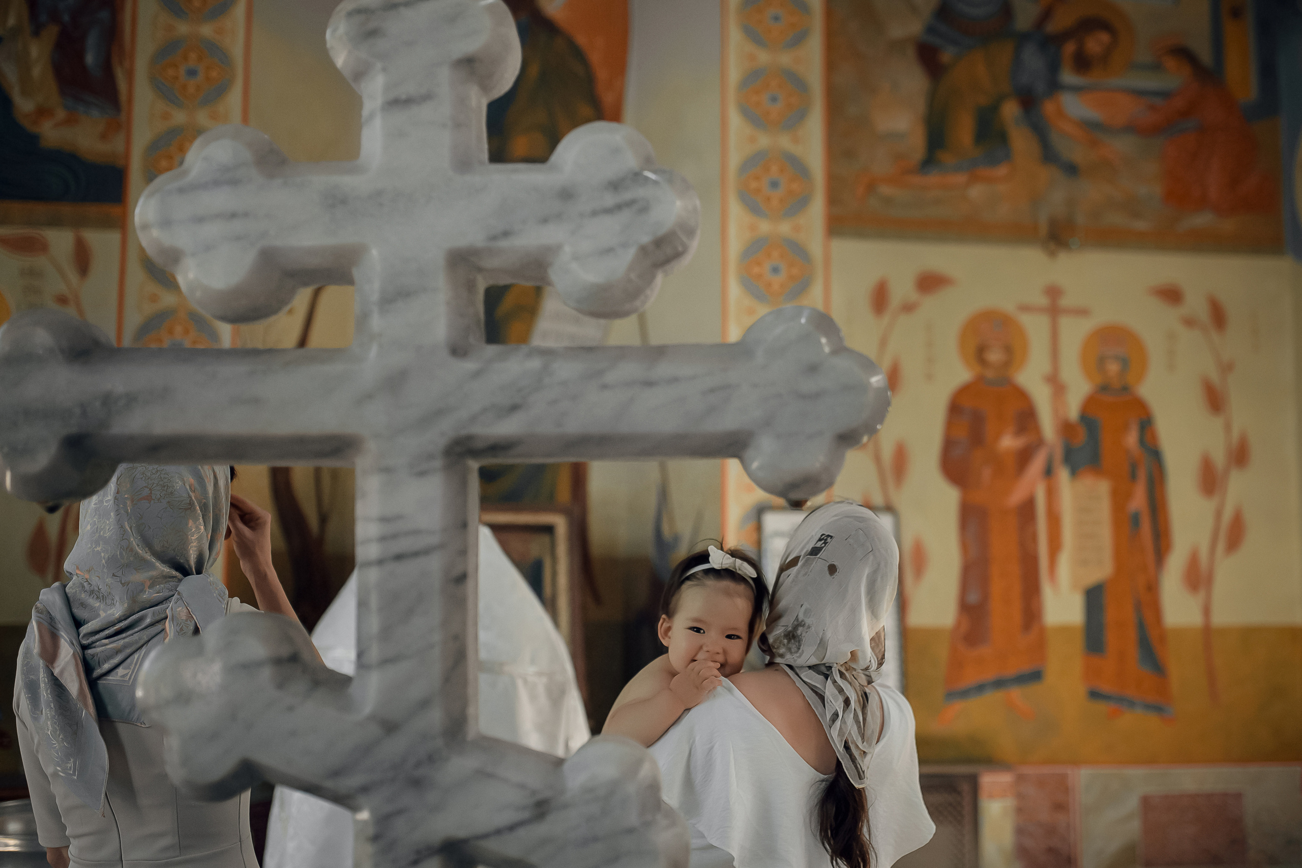 мама держит ребенка на крестинах в Ташкенте