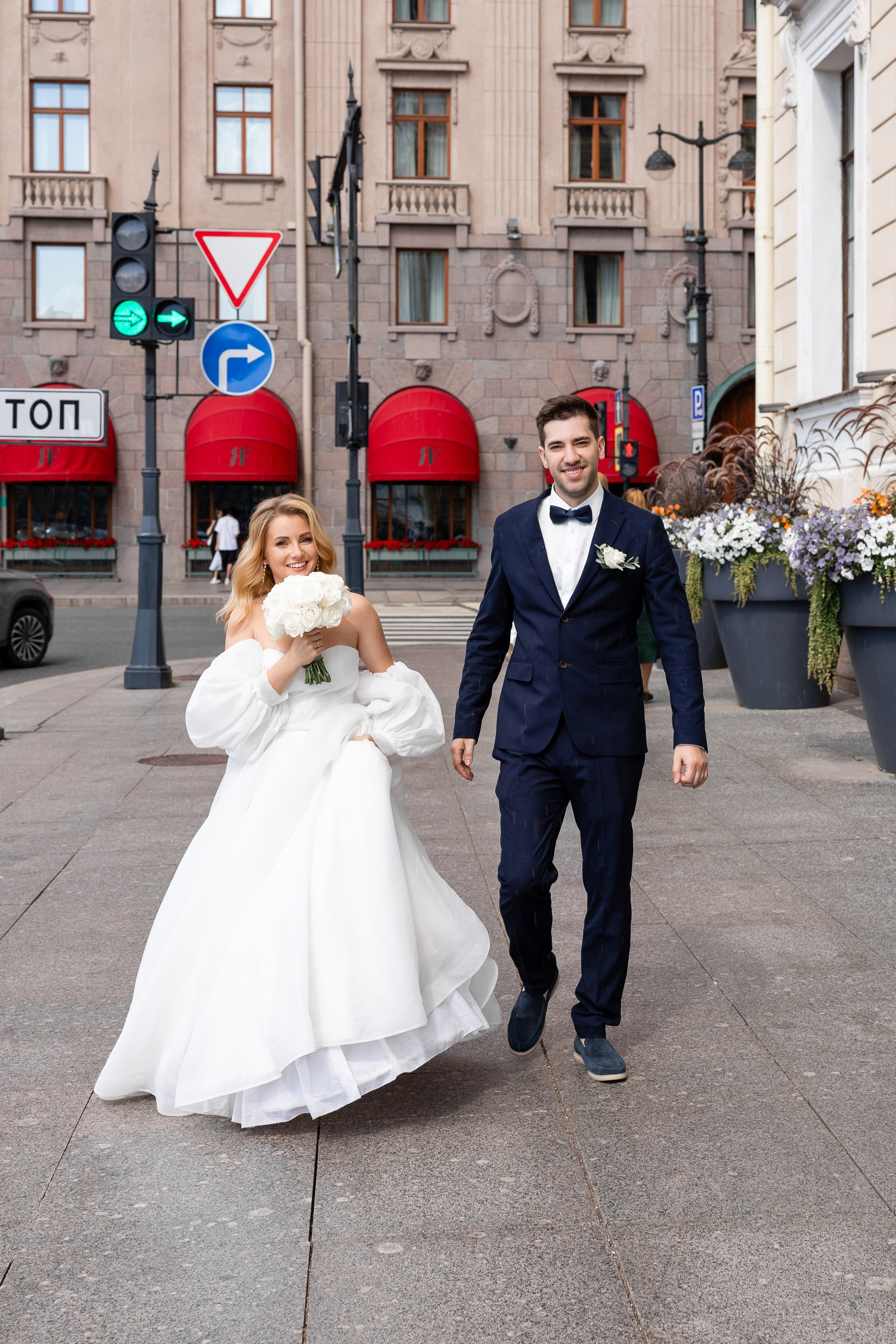 Молодожены идут на фоне гостиницы Астория