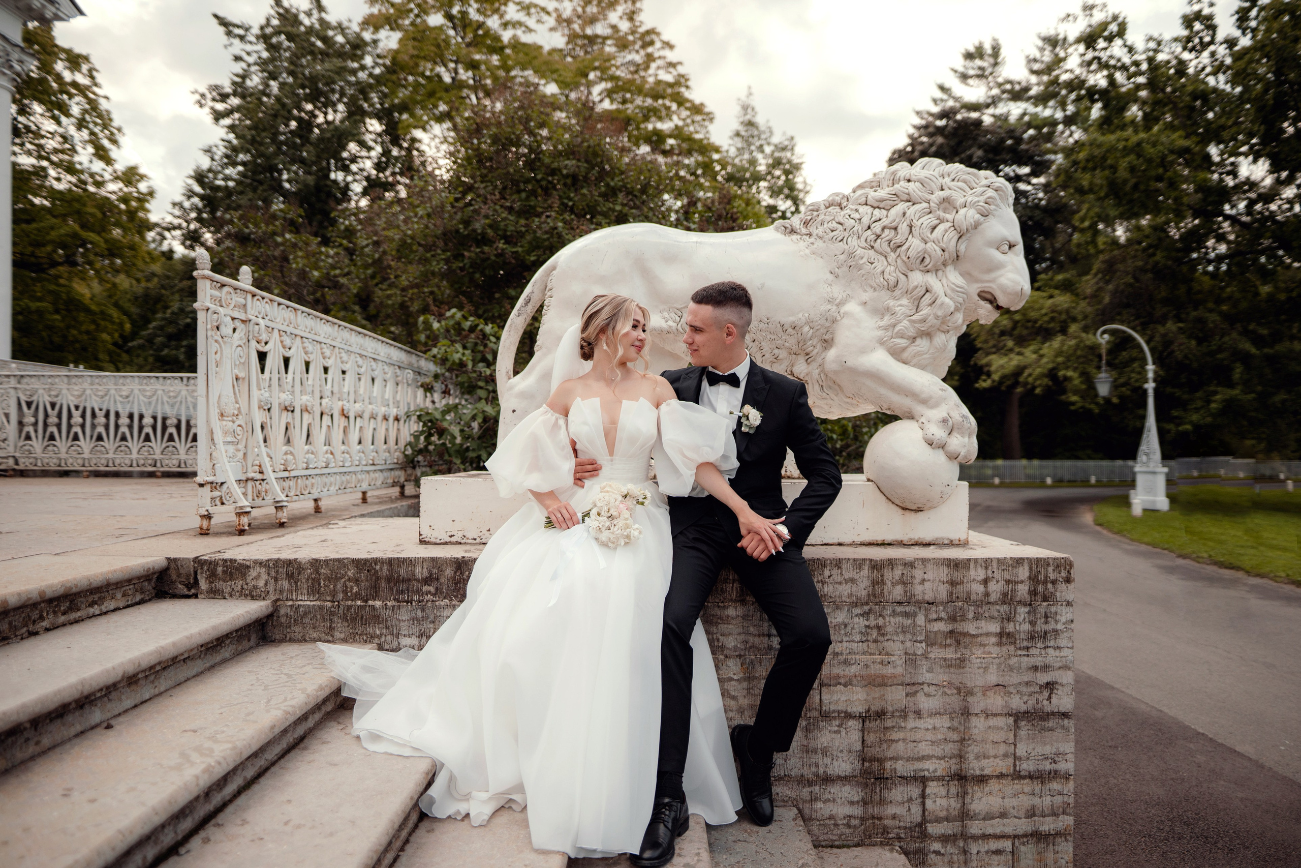 невеста и жених на свадебной фотосессии на Елагином острове у парадного крыльца со львами