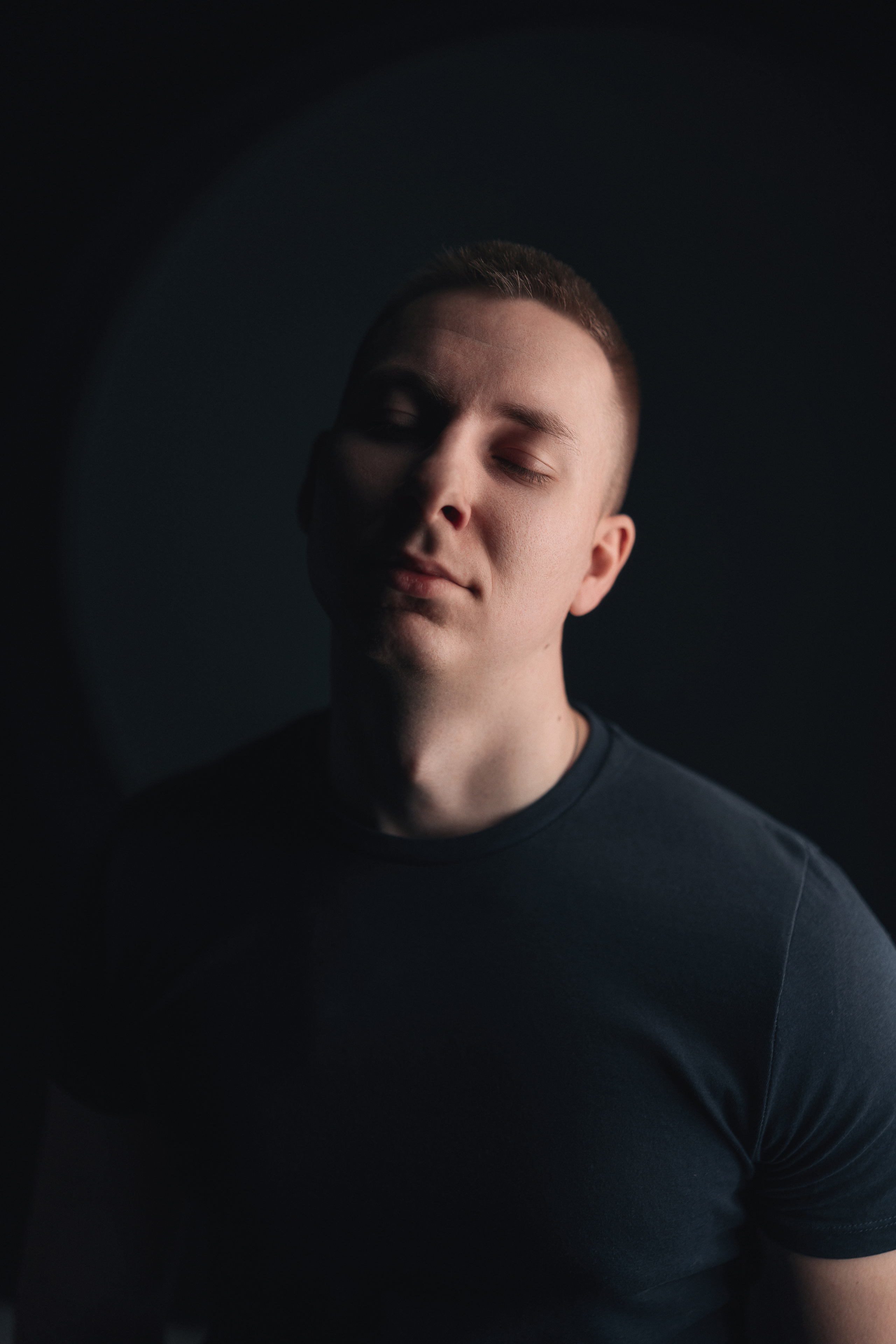 Парящий в мыслях парень в темной майке с одним источником света. Фотограф Роман Яковенко