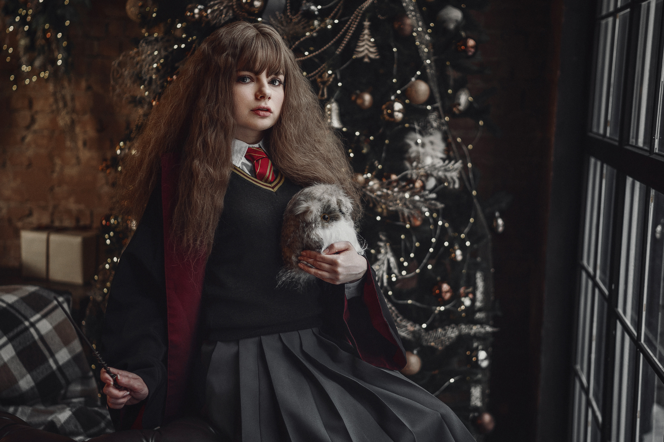 Девушка в образе Гермионы сидит на диване с совой