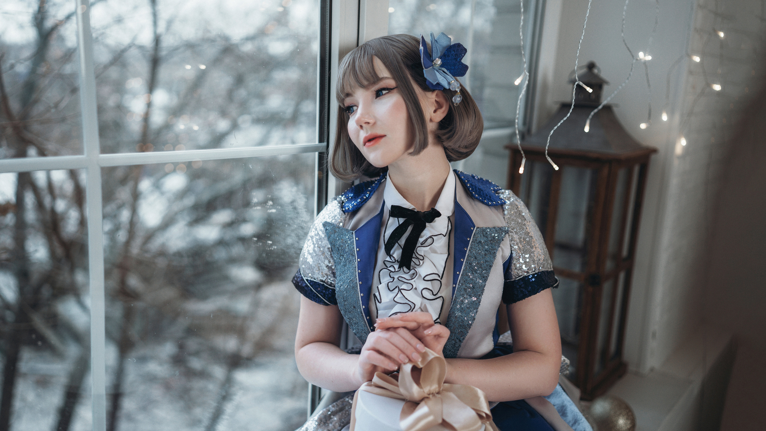 Девушка в синем платье сидит у окна и смотрит в даль. Фотография Романа Яковенко