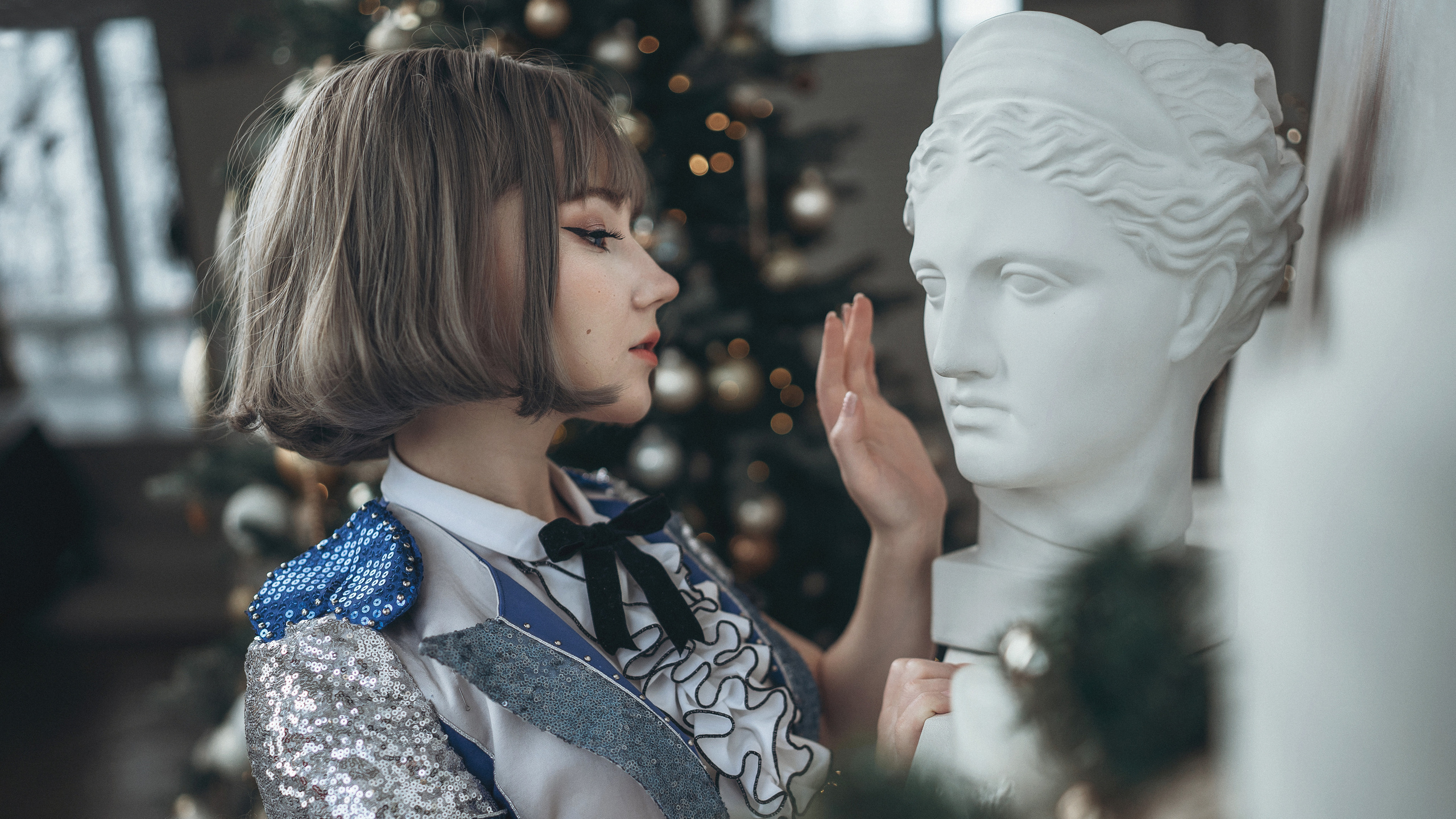 Девушка в синем платье дотрагивается до бюста головы мужчины. Фотограф Роман Яковенко