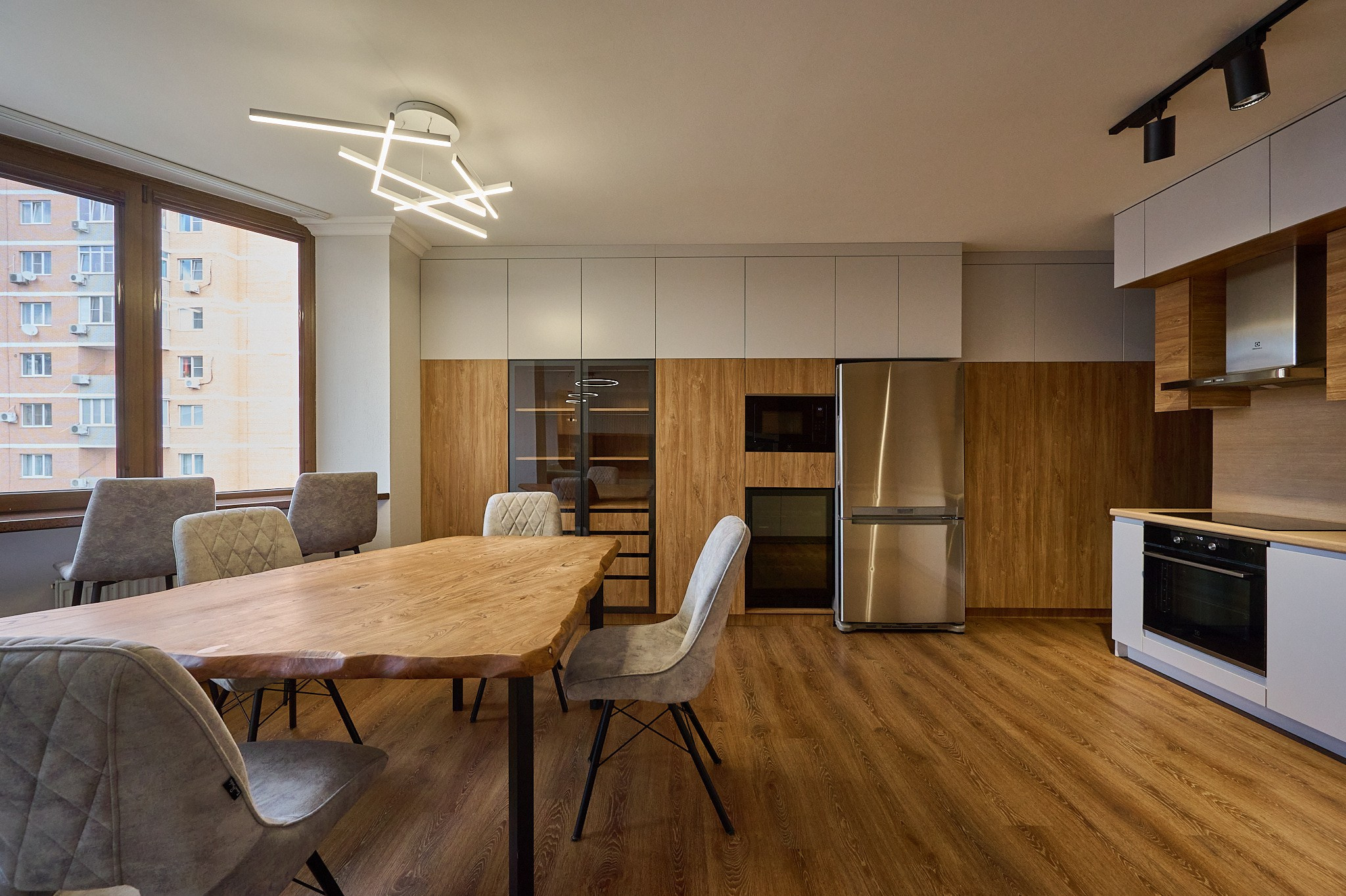 кухня деревянный стол серые стулья белые полки и ящики 