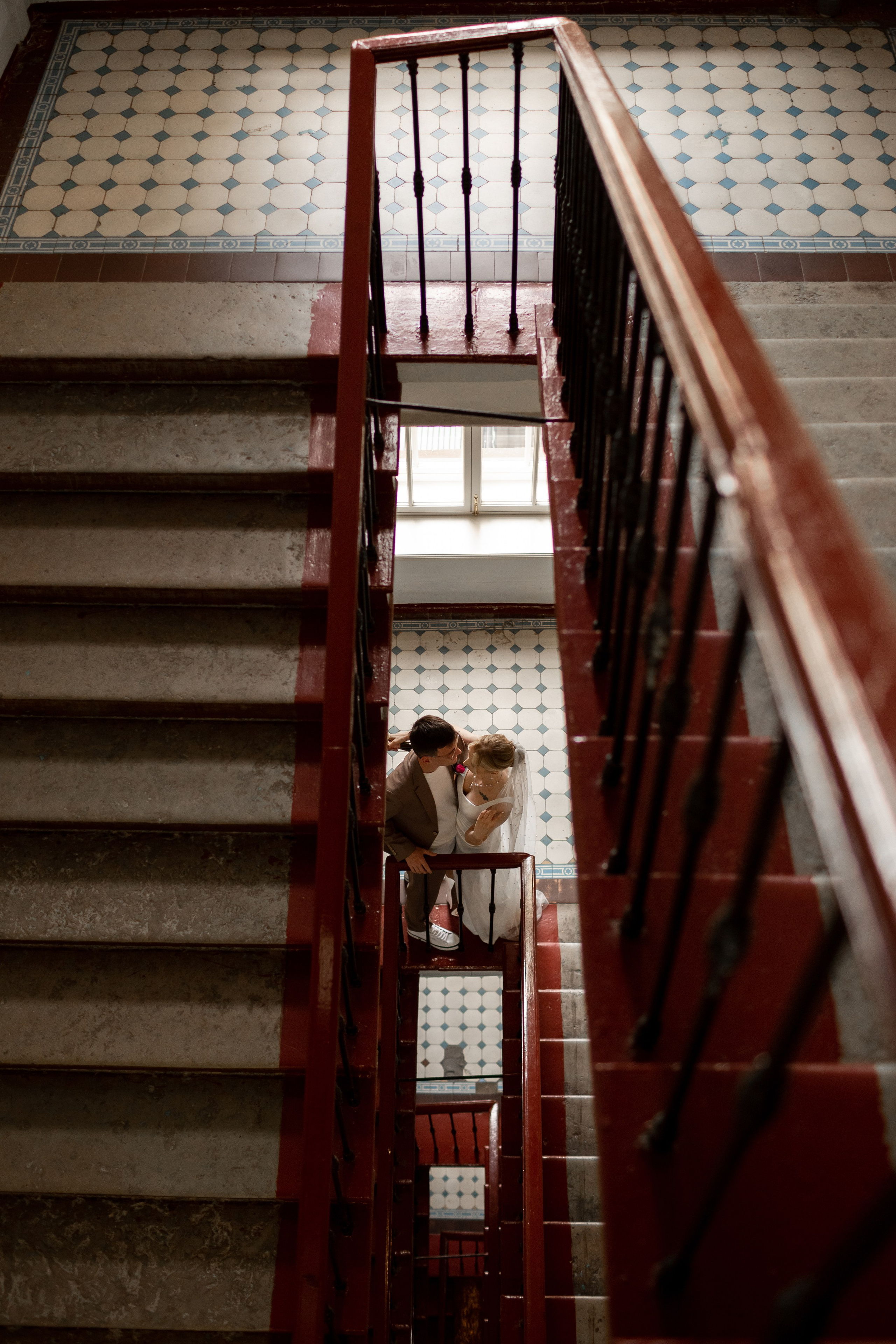 Необычная фотография в питерской парадной, жених и невеста целуются на лестнице.