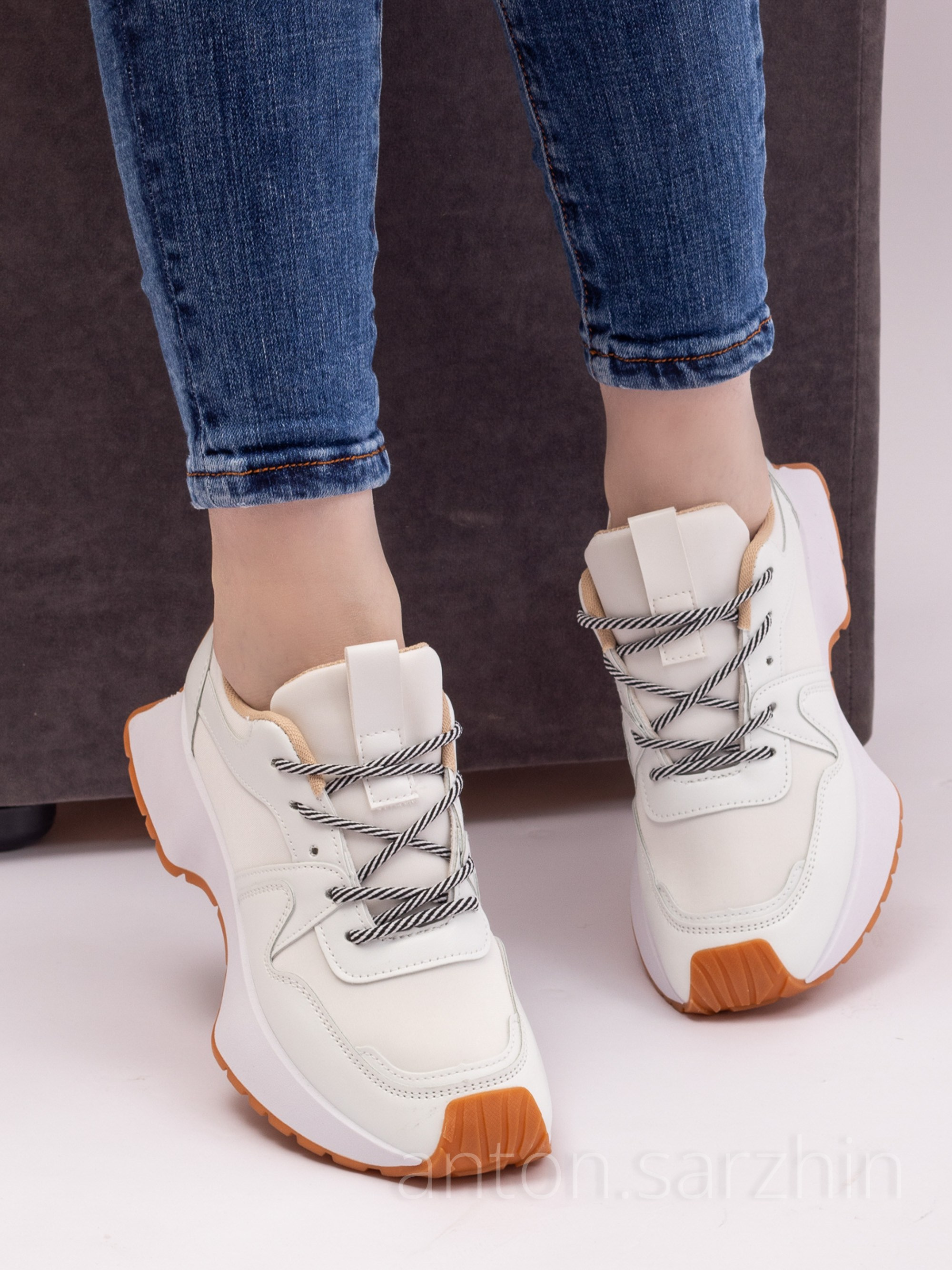 Съемка женских кроссовок на модели сидя на пуфе