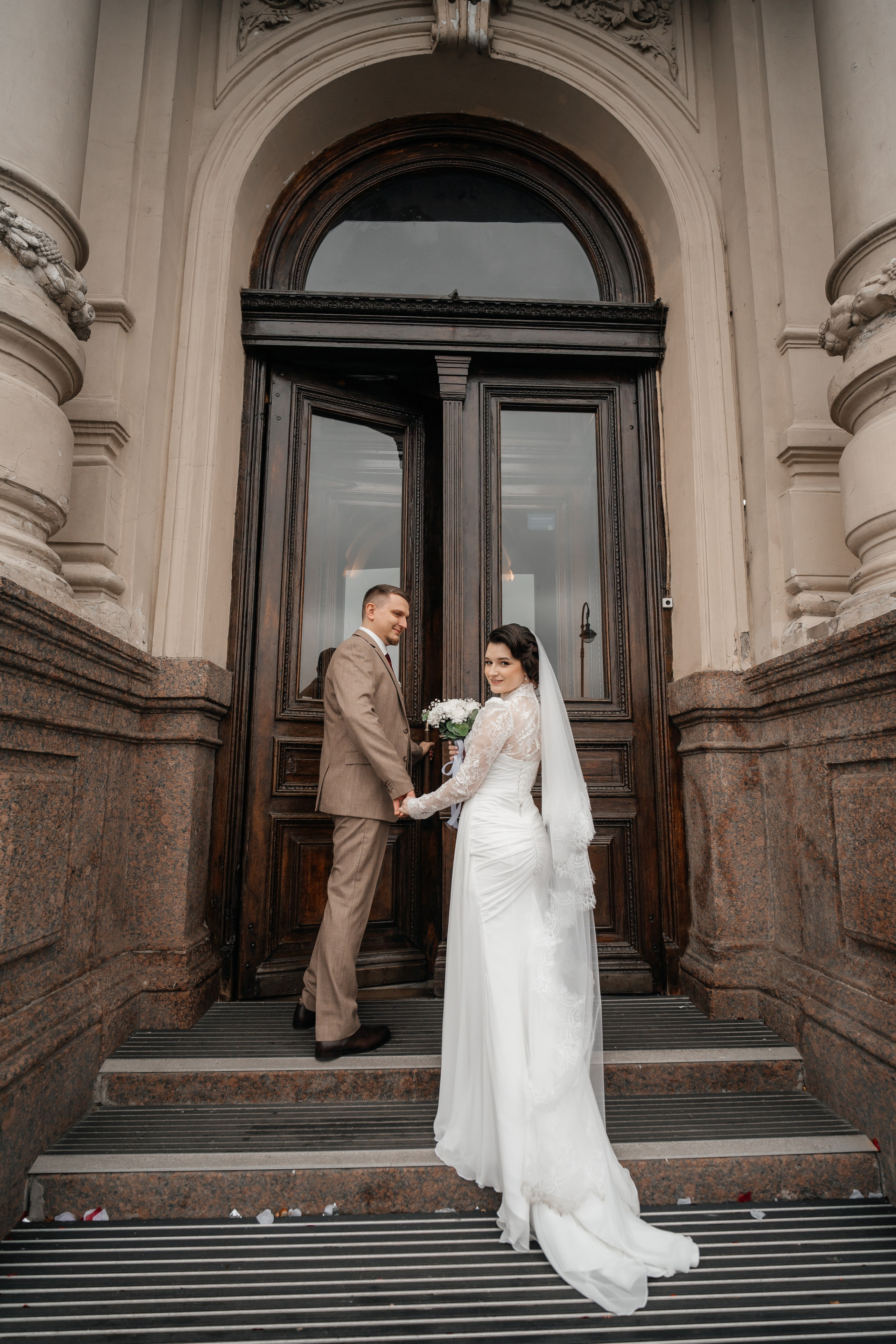Свадебная фотосессия во дворце бракосочетания №1 Жених и невеста стоят на крыльце загса.