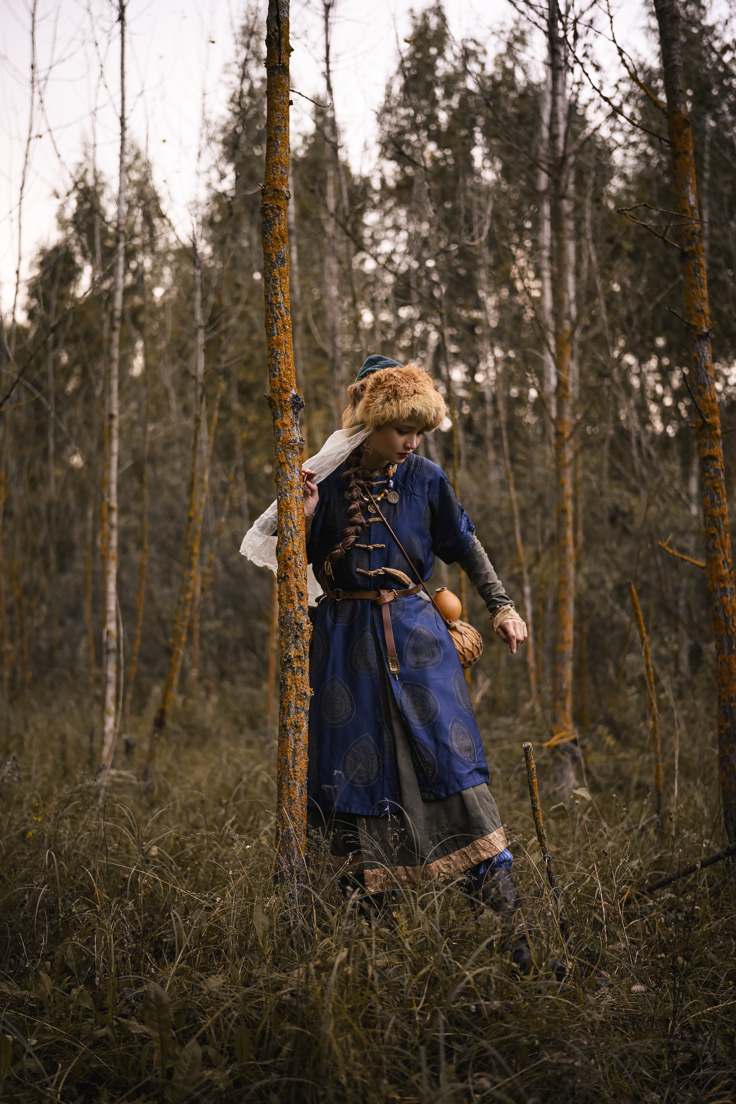 Художественная фотография женщины в историческом костюме среди лесной природы