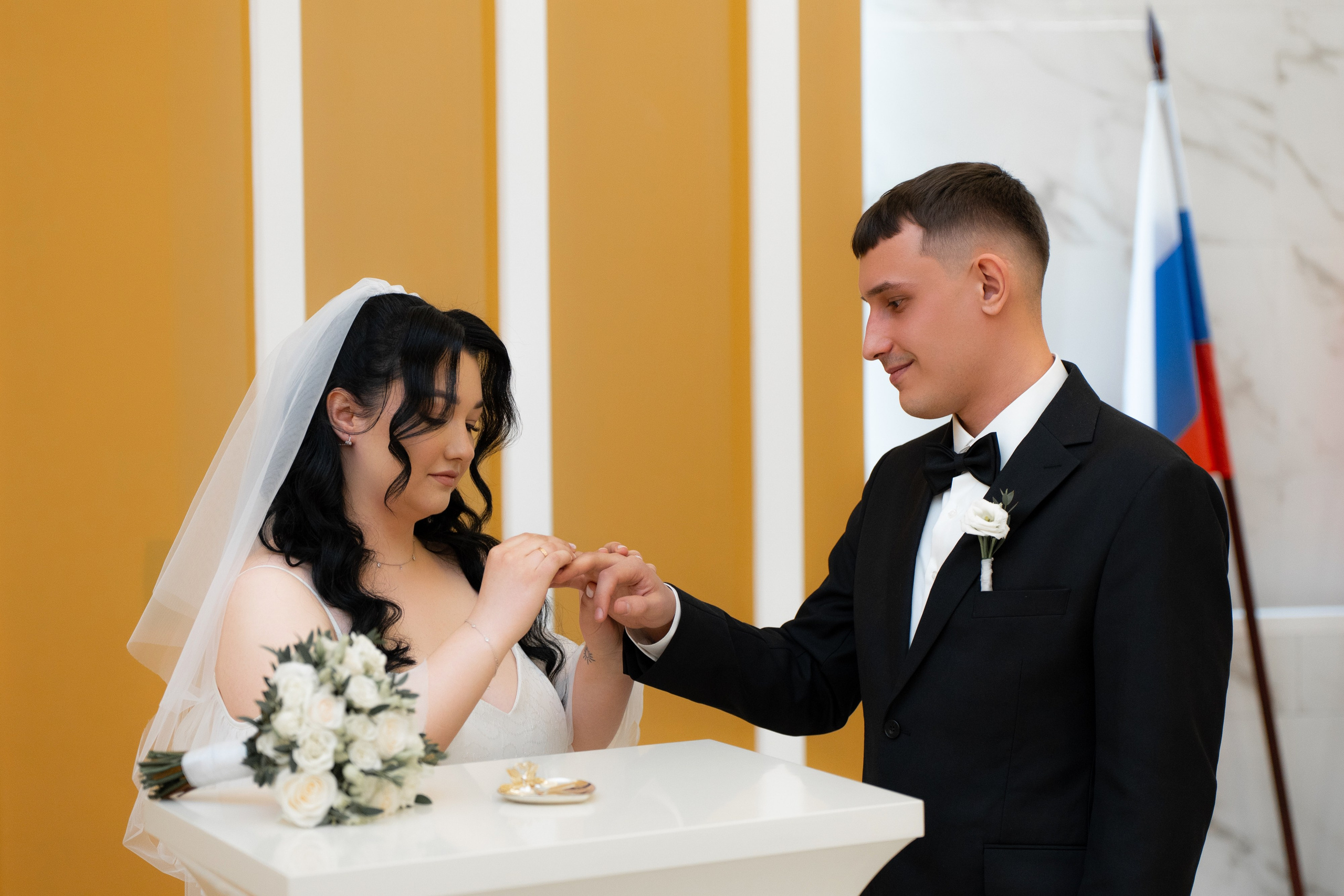 Свадебная фотосессия  в загсе Фрунзенского района на проспекте Славы в Санкт Петербурге молодые в зале обмениваются кольцами