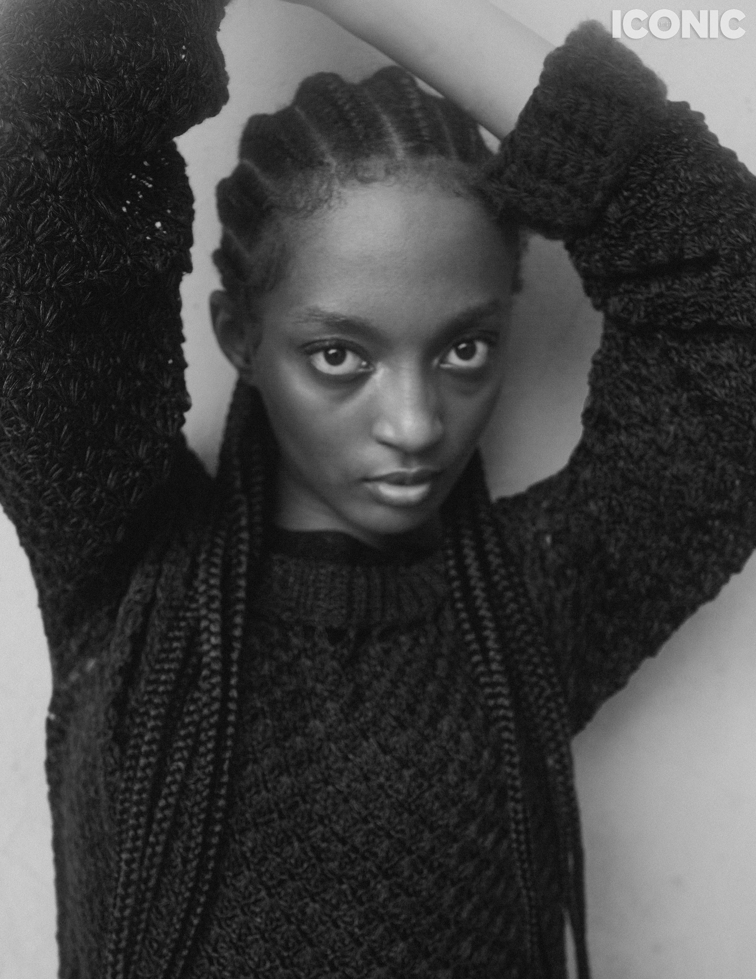 Темнокожая девушка с афрокосами и черном вязаном платье, публикация в журнале Iconic.