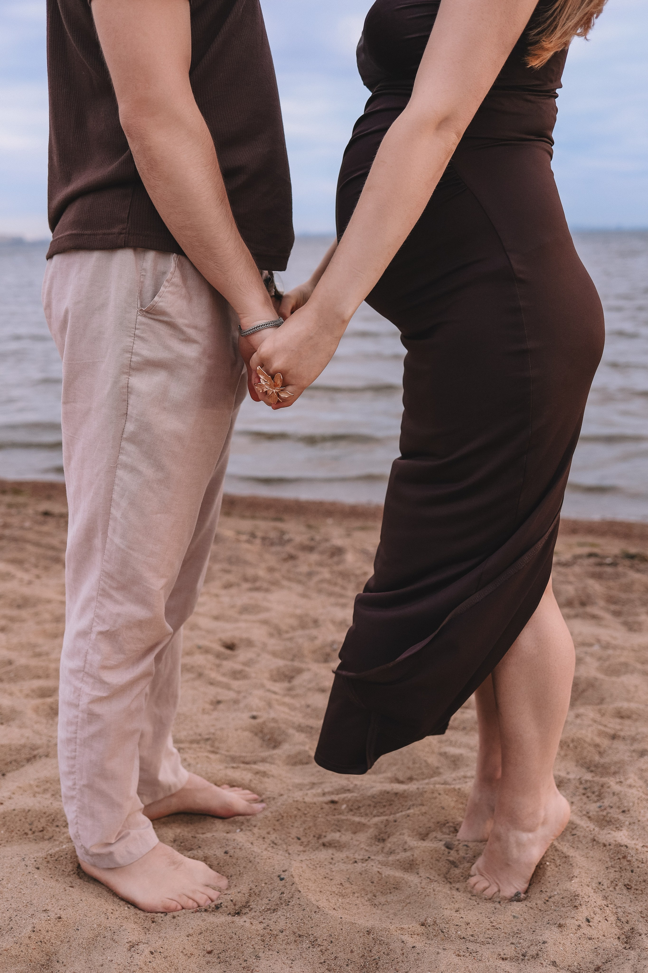 Ноги пары на песке, прогулка у воды