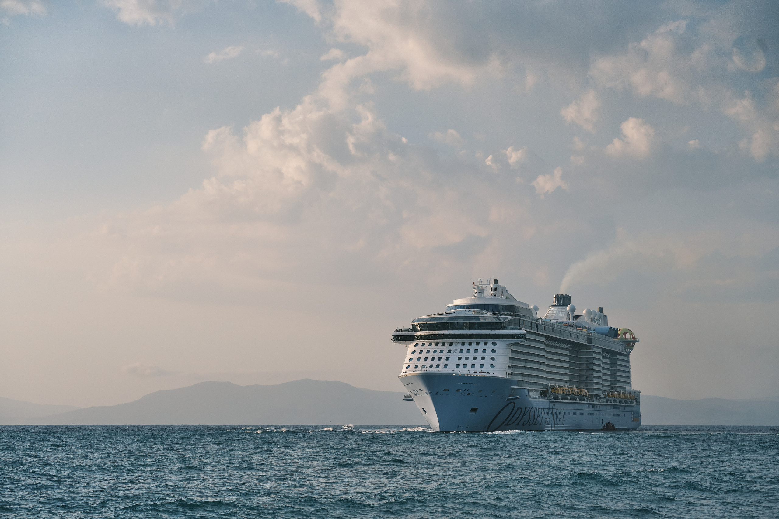 Большой круизный корабль курсирует в Эгейском море на фоне острова 