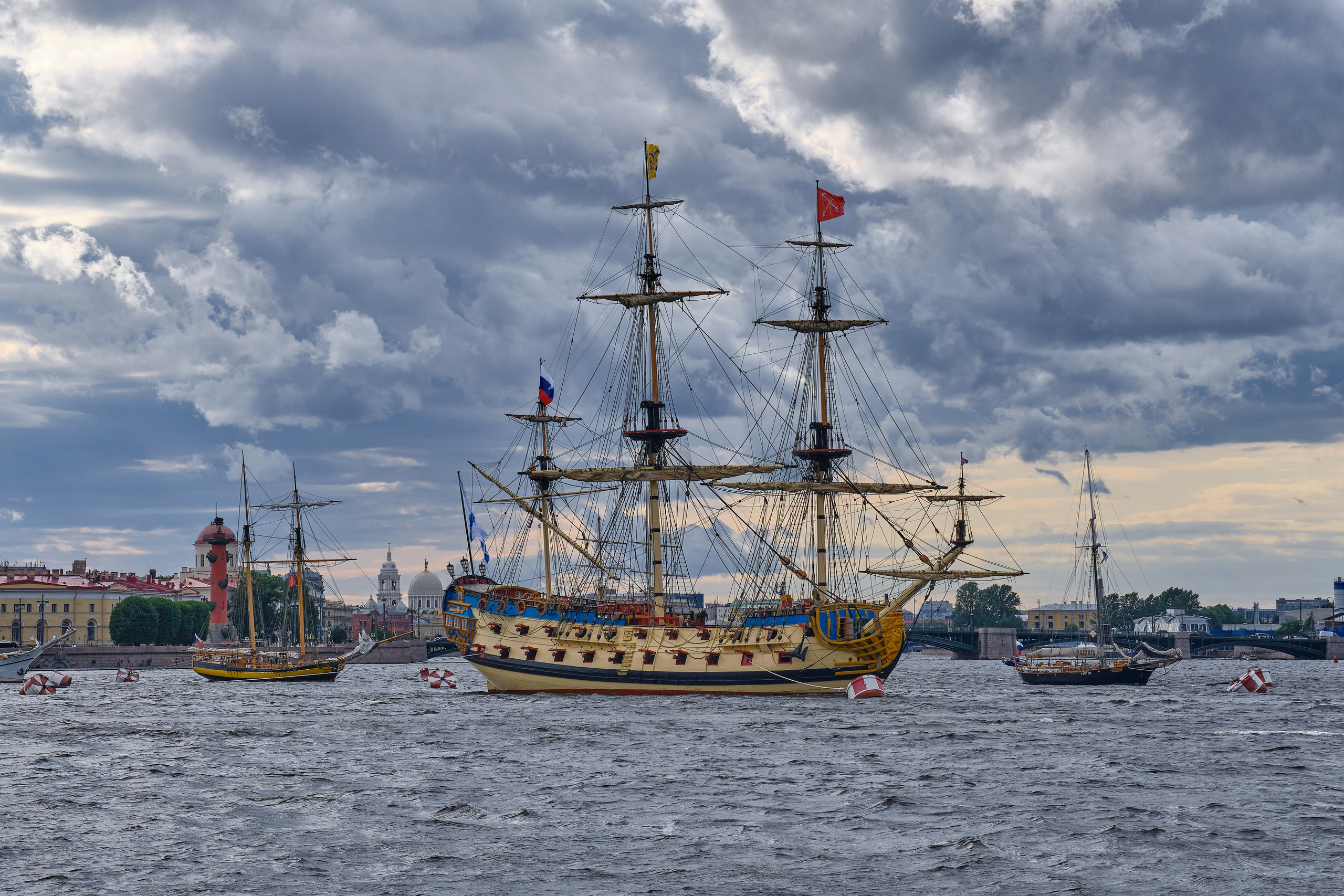 На реке Неве средневековый фрегат под Российским флагомна фоне Стрелки Васильевского острова в Санкт-Петербурге